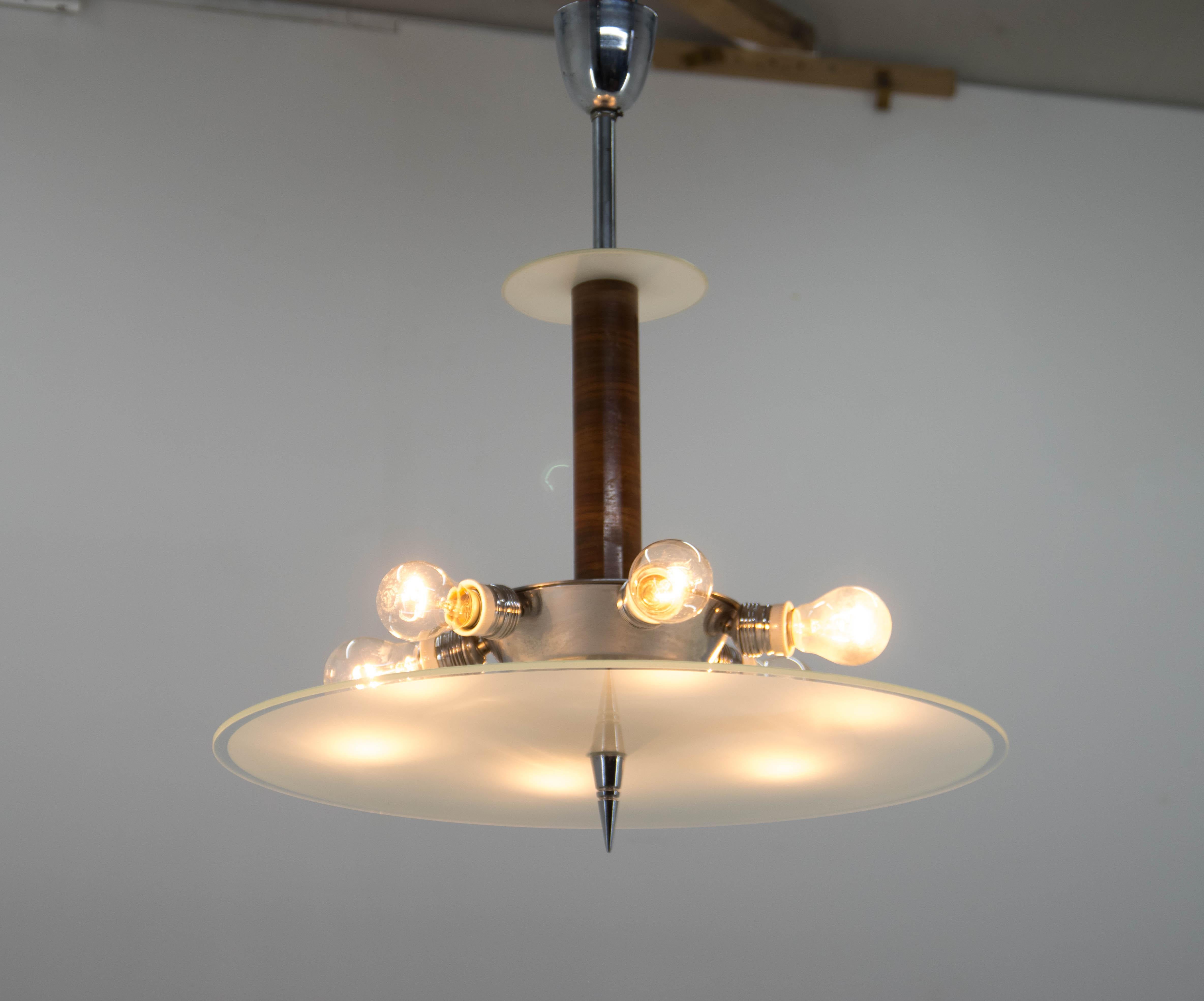 Unusual Art Deco or Functionalist chandelier made of walnut, chrome and glass.
Cleaned, rewired
two separate circuits: 3+3x60W, E25-E27 bulbs
US wiring compatible.