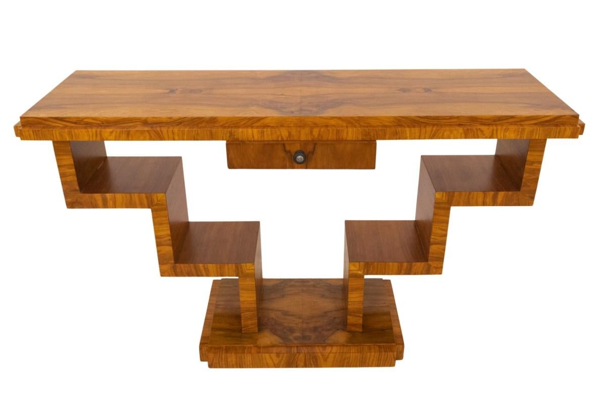 Consolle in noce Art Deco unica nel suo genere, Polonia, metà del XX secolo.

Questa consolle Art Deco dalla forma geometrica unica è realizzata in noce e dispone di un cassetto per i piccoli oggetti.

In ottime condizioni, dopo la