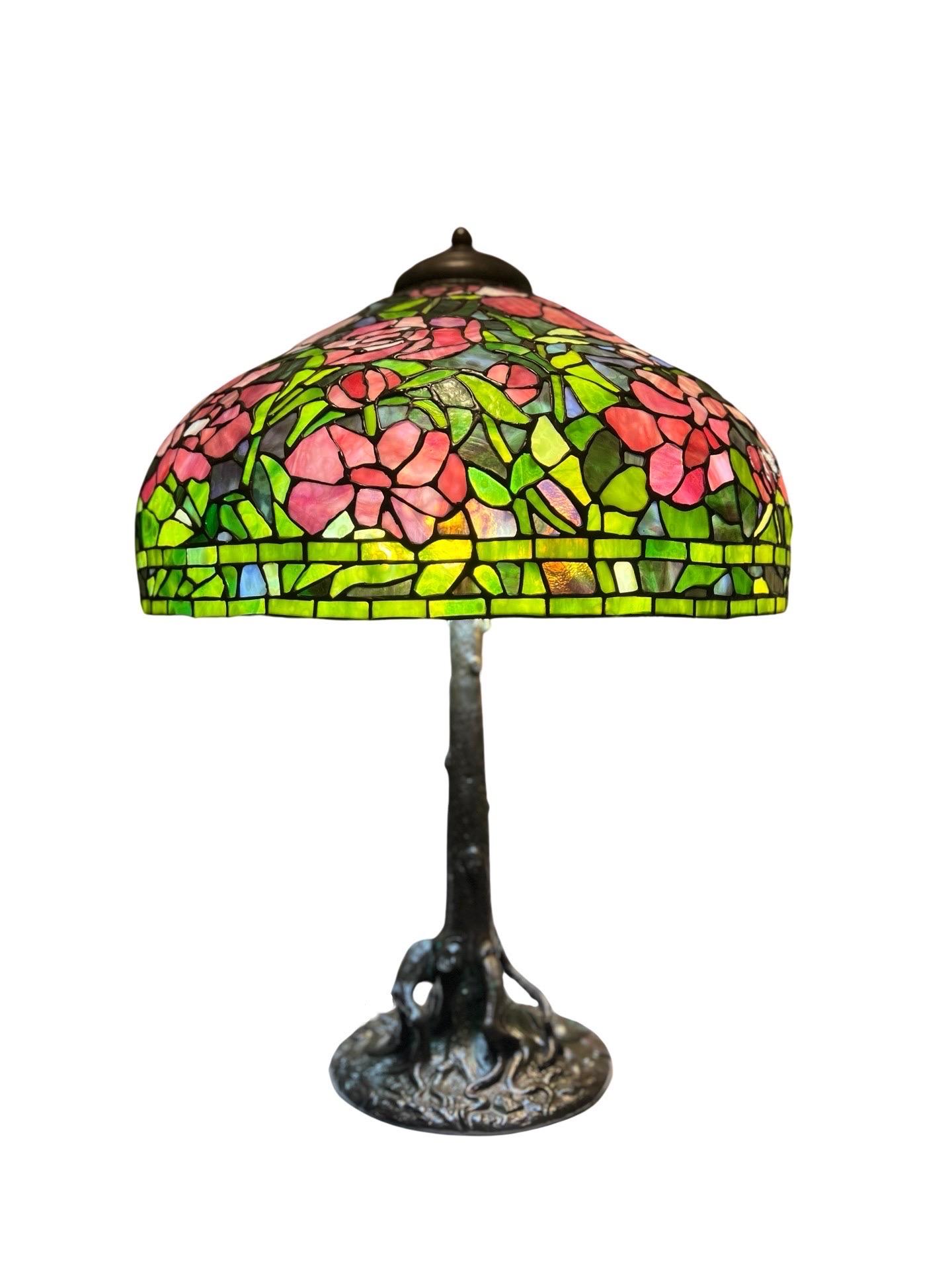 Unique Art Glass & Metal Company (New York, actif entre 1889 et 1917), vers 1915. 
Cette magnifique lampe de table en verre au plomb a été produite après l'expiration, en 1903, du brevet de Louis Comfort Tiffany sur la célèbre technique de la