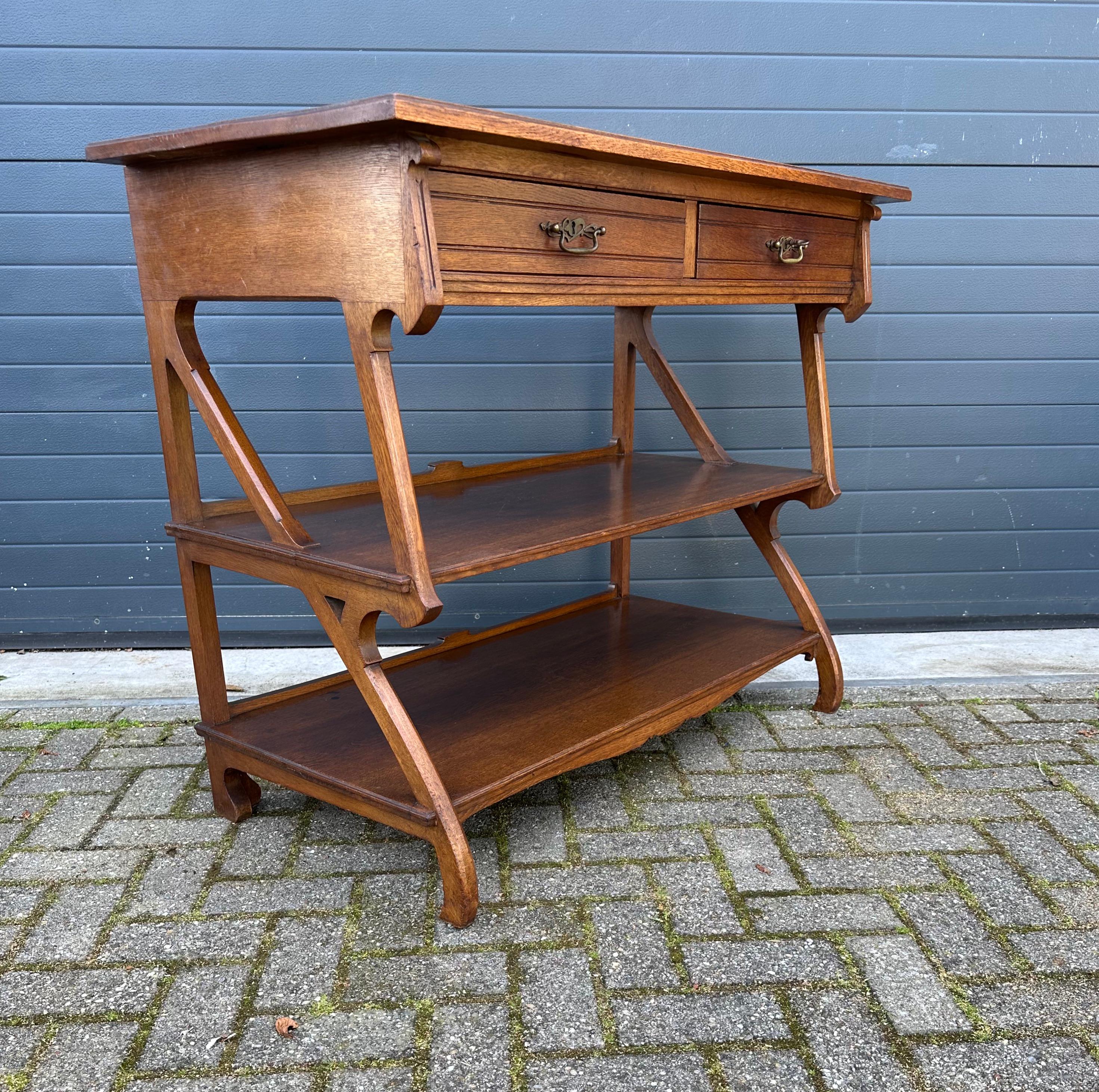 Pure Art Nouveau and good size, three shelf side table.

This early and good size, Arts & Crafts period sideboard with its stunning design makes a great statement piece for your private library or living room. In our view this is not merely a