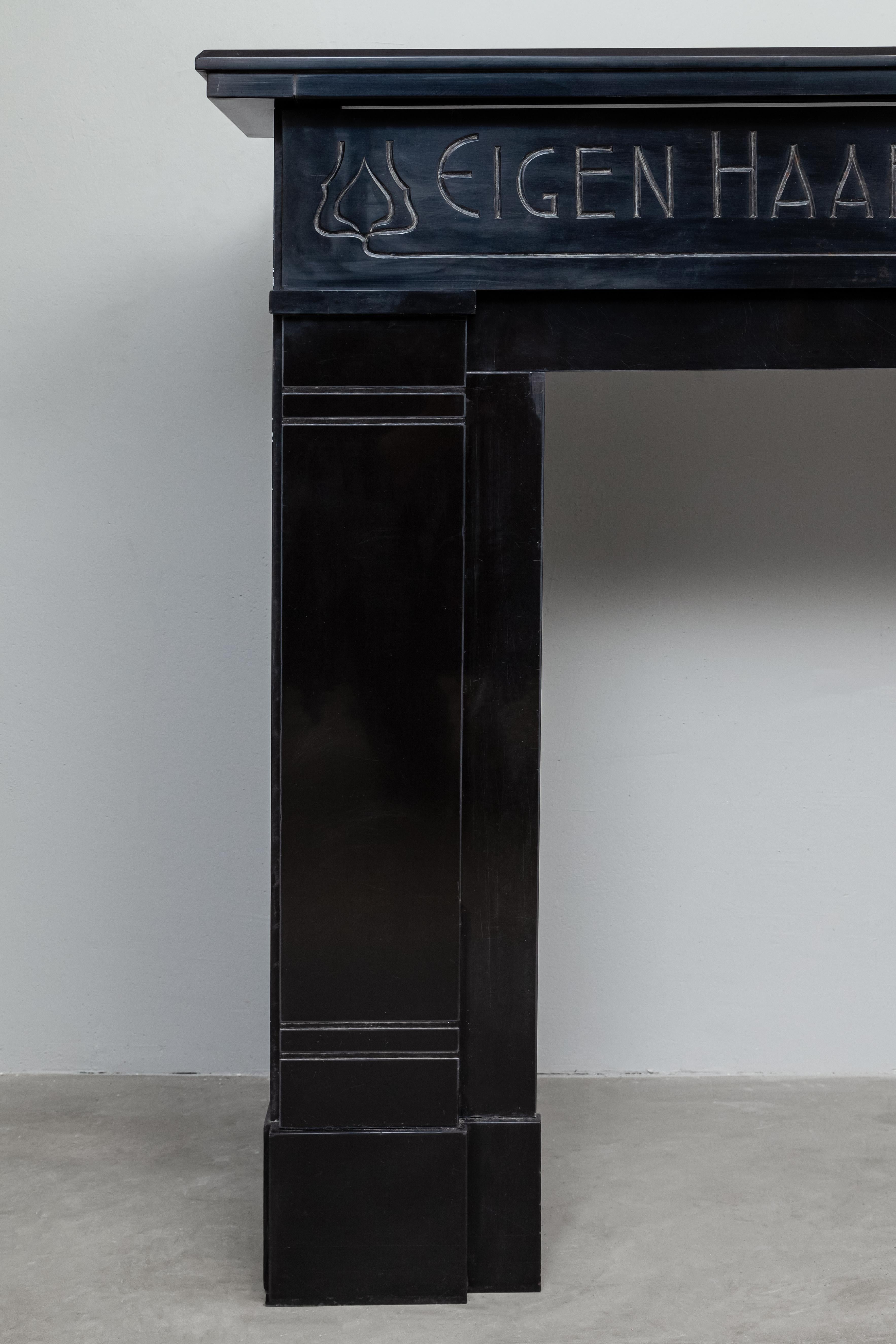 Cette cheminée unique en marbre noir antique a probablement été commandée. La façade est décorée par le texte : There's no place like home. (Traduction) Cela rend ce Noir de Mazy surround unique. L'origine de cette cheminée ne nous est