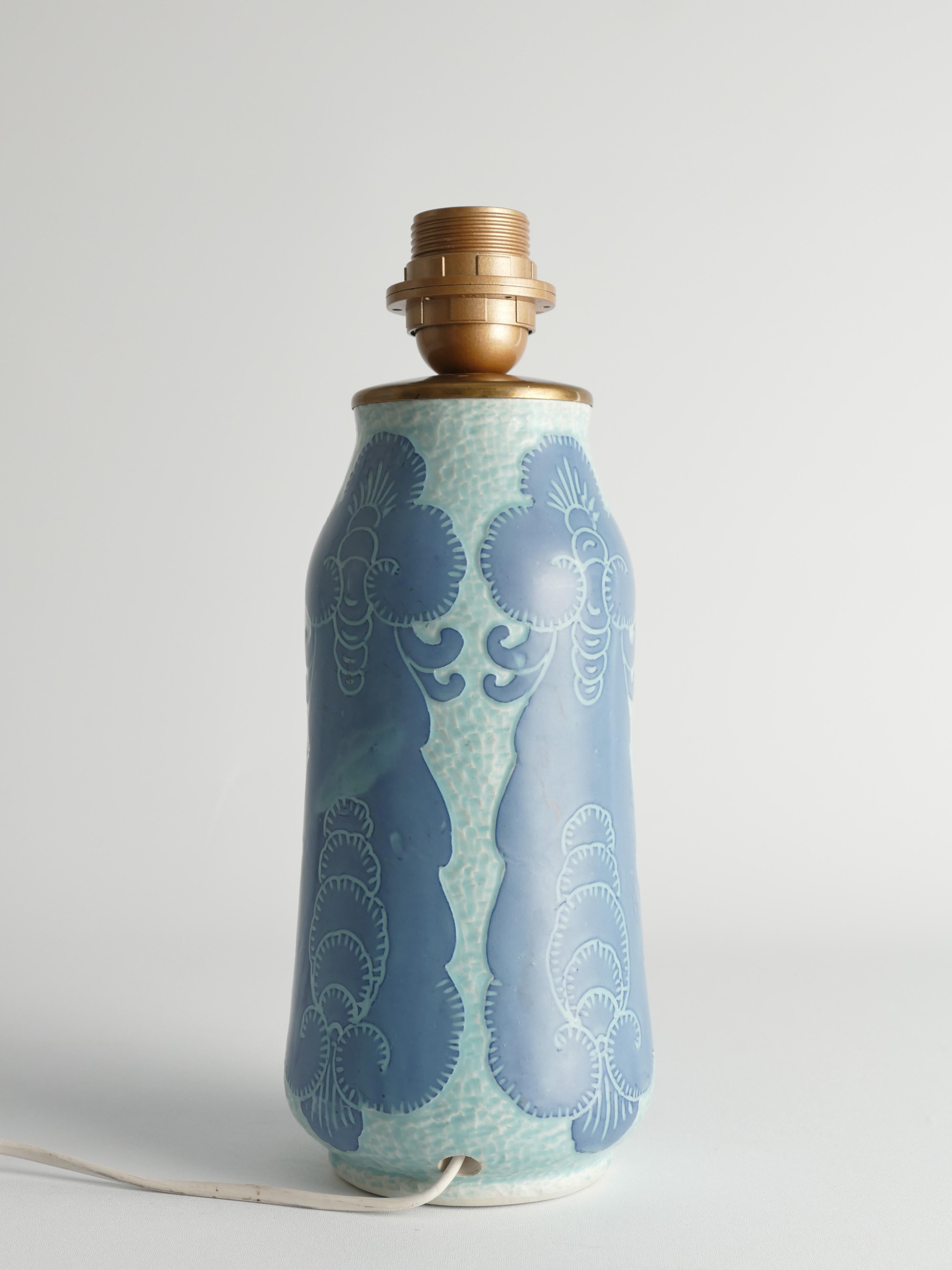 This art nouveau table lamp is designed by Josef Ekberg for Gustavsberg, Sweden, 1919. An exemplar of art nouveau design, this vase, crafted by Josef Ekberg for Gustavsberg, showcases a combination of pale blue ground and mid-blue decoration using