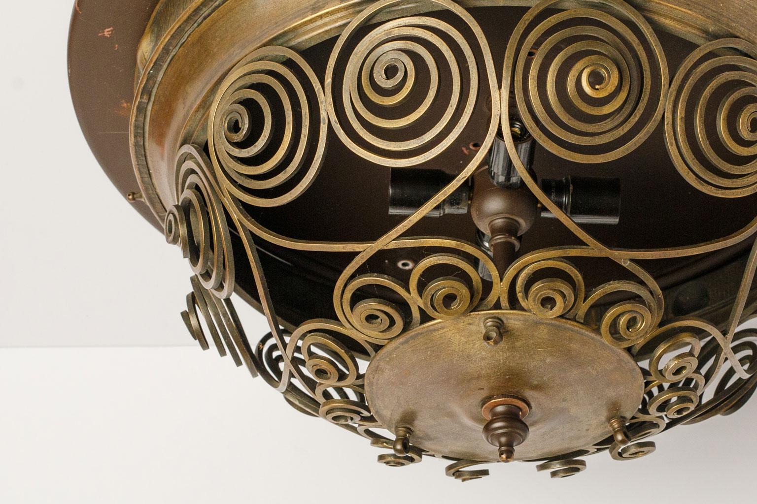 Unique Austrian flush mount light created, circa 1920-1940 from cut and hammered brass. Decorated in crossed swirling scrolls and lit by four candelabra-size bulbs. Newly wired for use within the USA and ready to install.