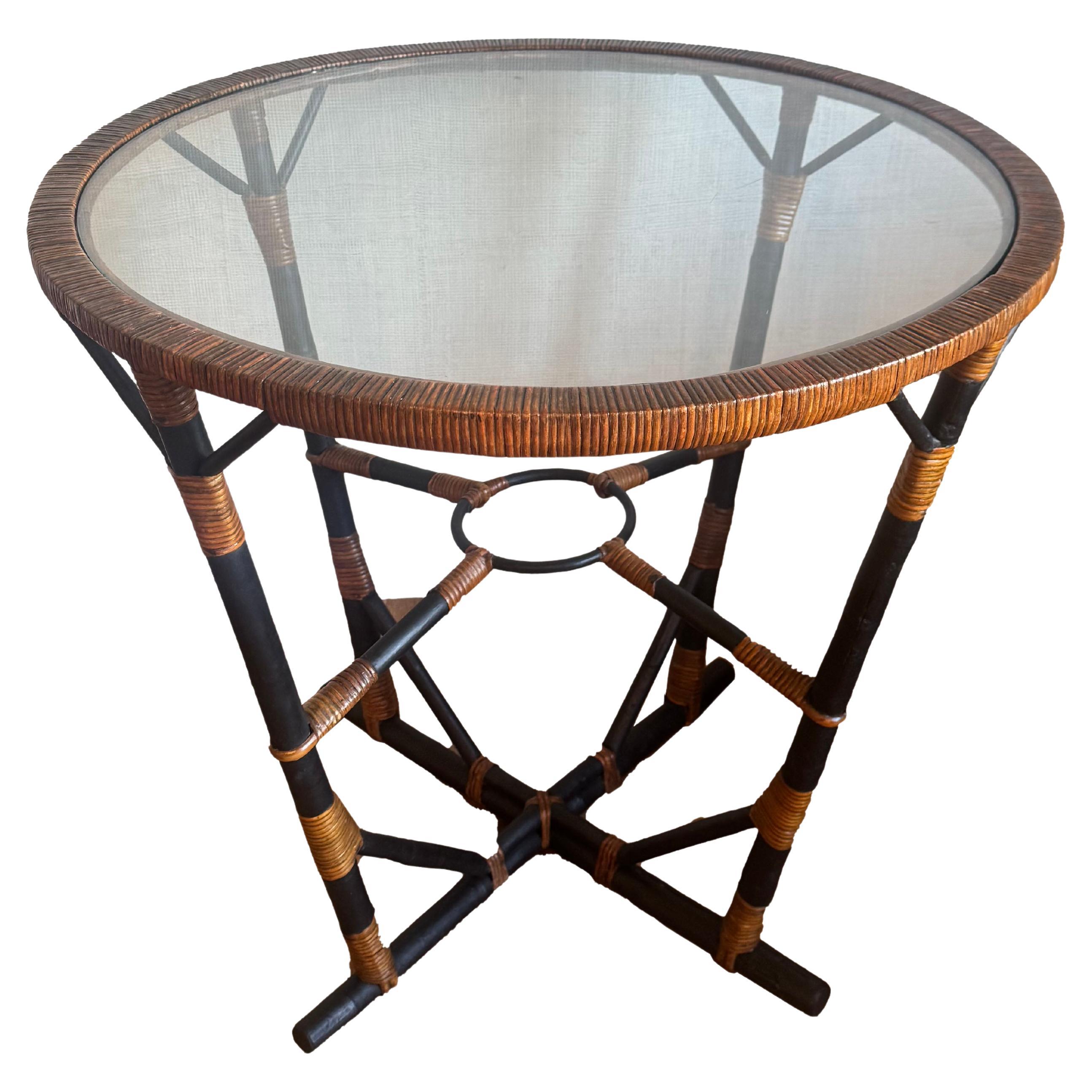 Cette superbe table d'appoint est une pièce vintage magnifiquement remise à neuf, dégageant un mélange intemporel de charme bohème et tropical. Fabriqué à partir de bambou et de rotin robustes, il présente une étonnante finition personnalisée à la