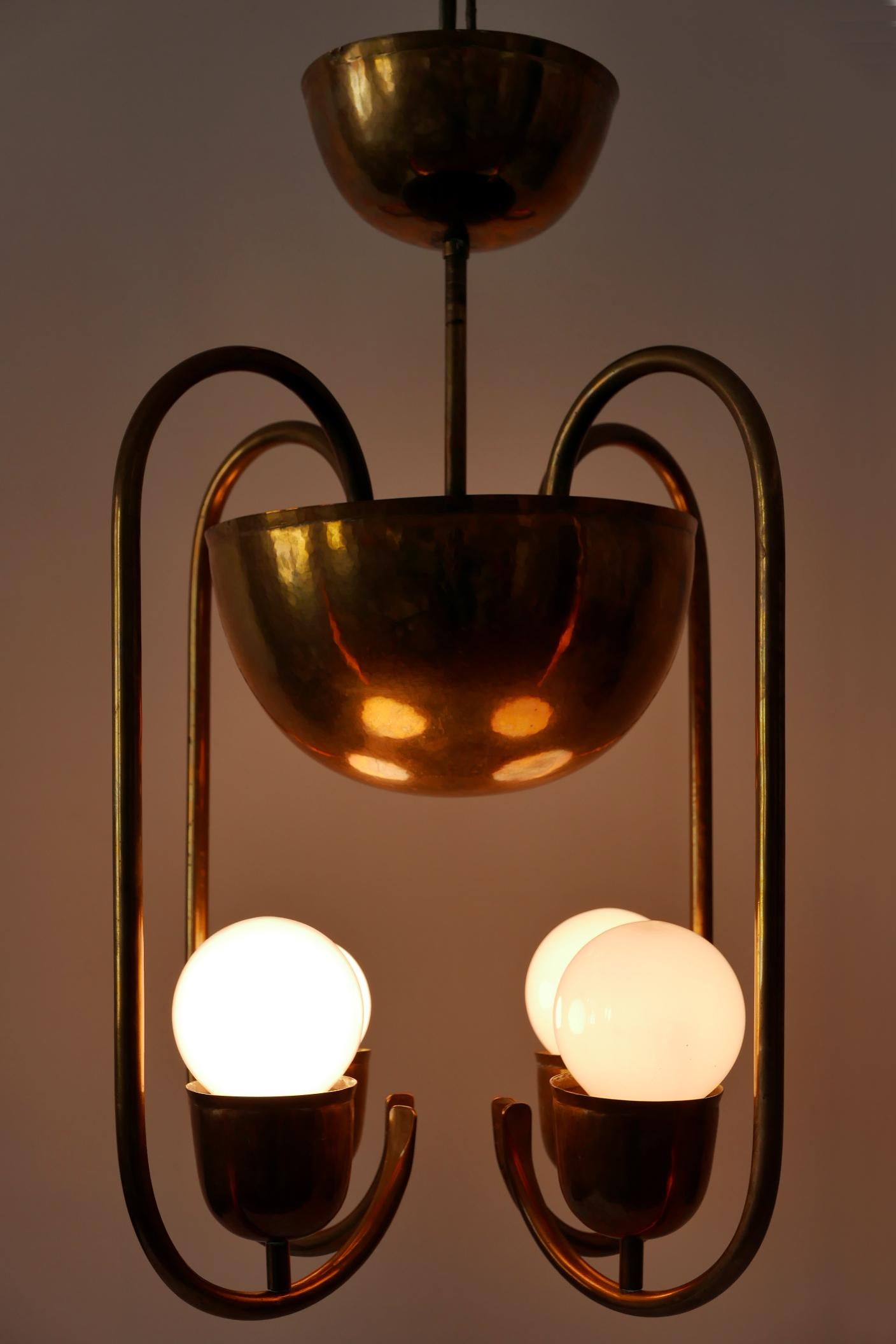 Unique work of the famous Bauhaus metal artist Hayno Focken: four-armed Bauhaus / Art Deco chandelier or pendant lamp in hammered solid brass. Probably a custom work in 1930s, Lahr, Germany.
Makers mark to the canopy (see the last image).

Hayno