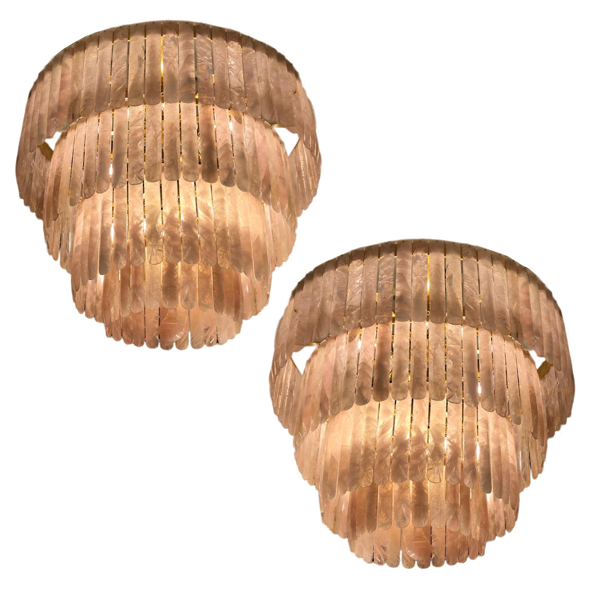 A pair of beautiful rose quartz chandeliers comprising 4 cascading bronze circular tiers each profusely hung with 175 individually hand carved rose quartz crystal drops. A spectacular solid rose quartz saucer is inset in the lower bronze ring with a