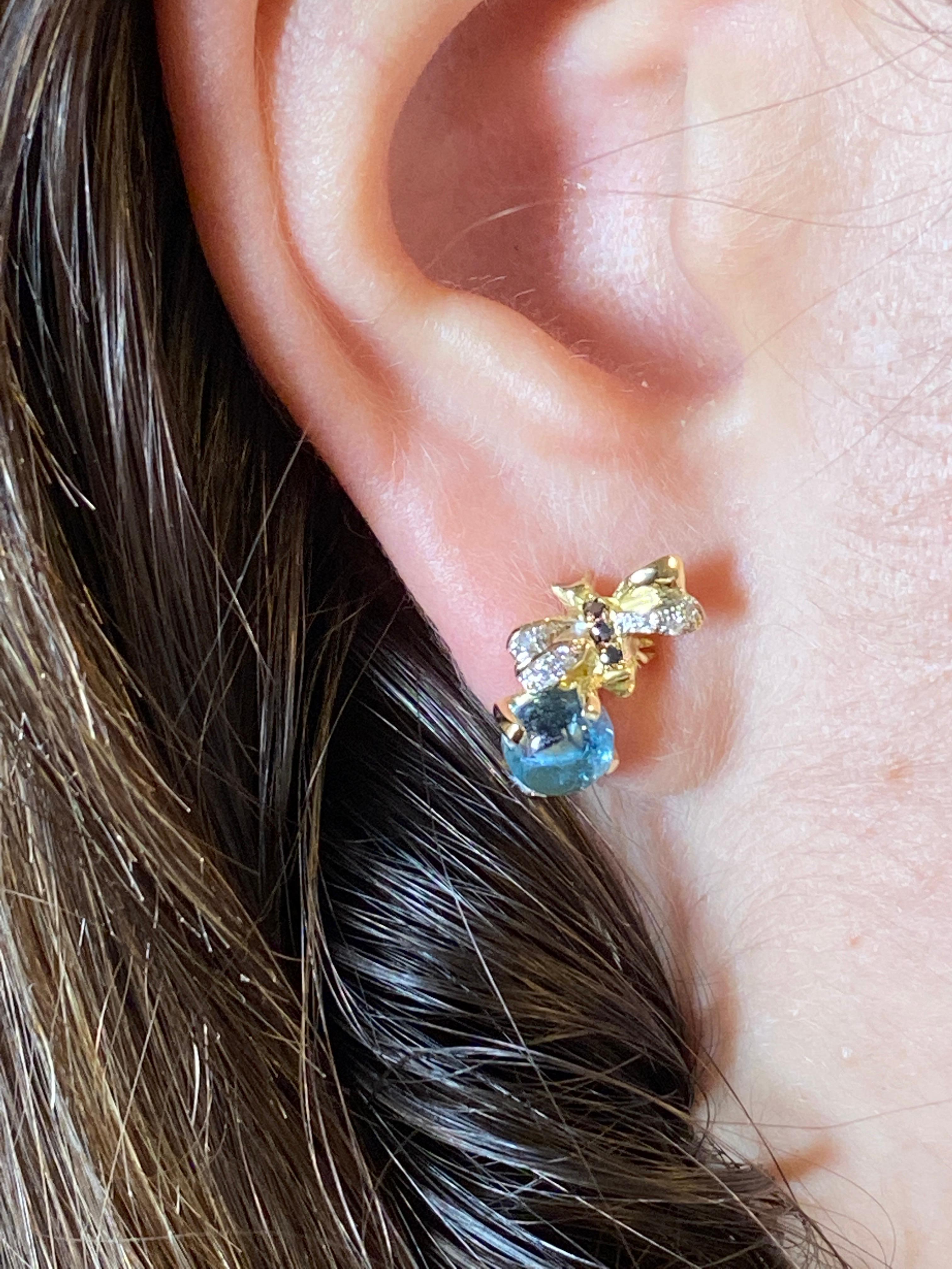 Rossella Ugolini's bee-shaped stud earrings Handcrafted in Italy in 18k Yellow Gold, with 0.16 White and Black Diamonds and 2.20 Aquamarine, are a perfect blend of elegance and whimsy. 
The bee shape is inspired by the beauty and harmony of the