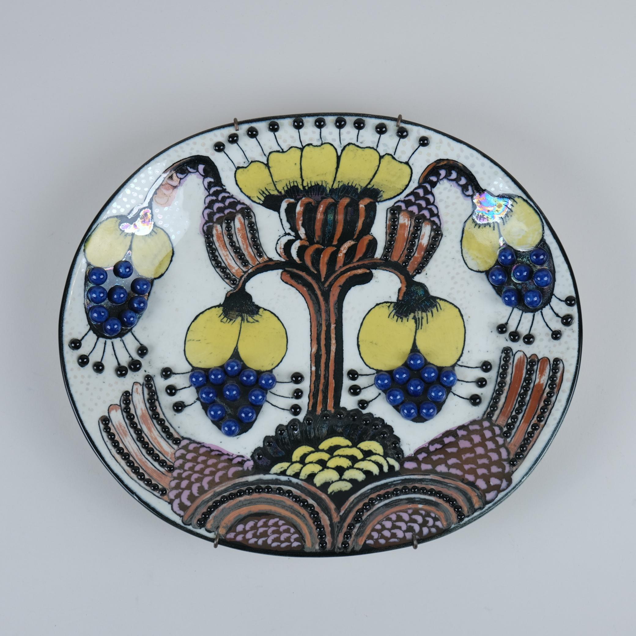 Si tratta di un bellissimo piatto unico in ceramica decorato con perline multiple ed è un buon esempio dell'abilità dell'artista nell'utilizzare colori e dettagli di smalto iridescente sulla superficie del piatto. Kaipiainen ha introdotto le perle