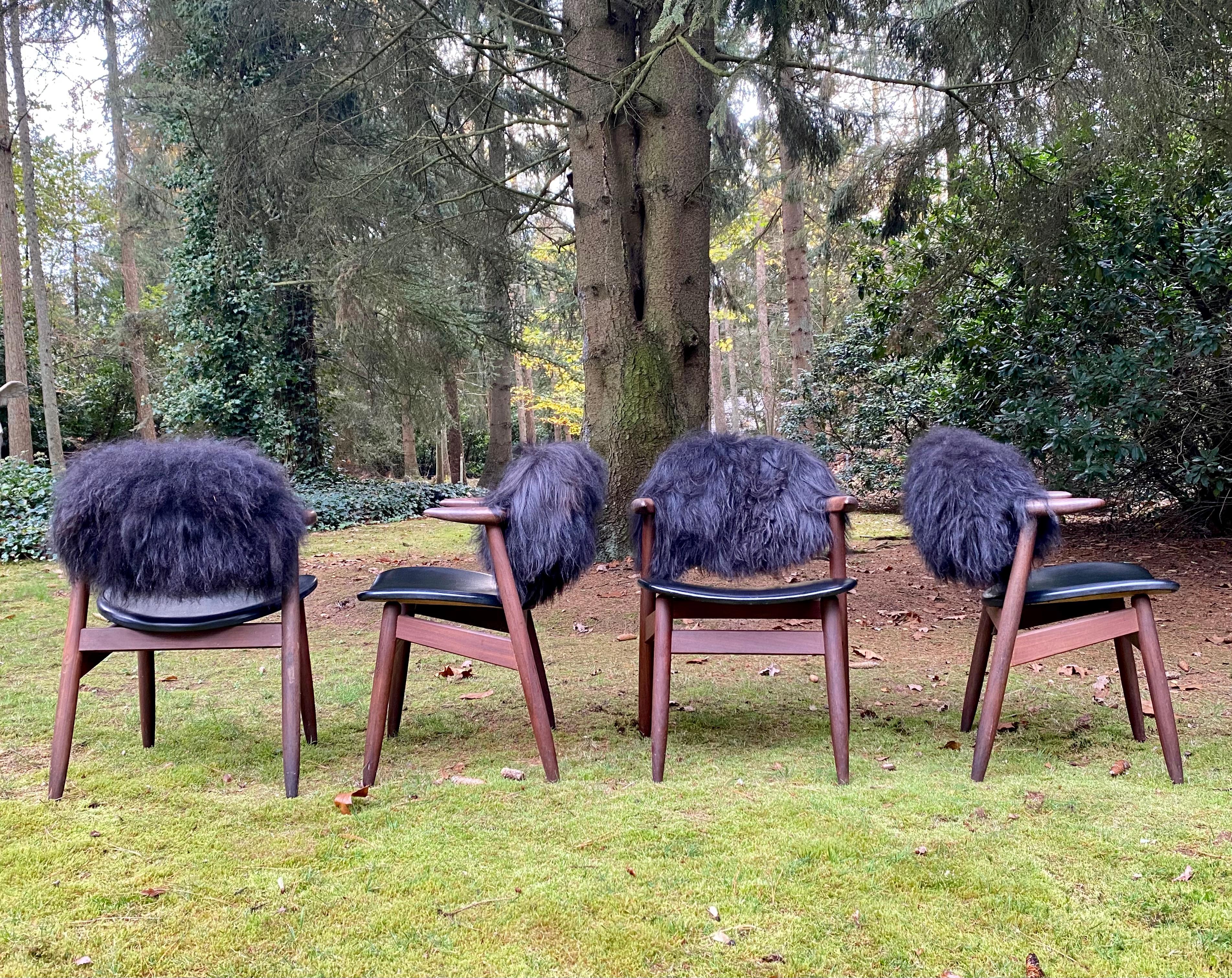 Outstanding set of four Cowhorn chairs, with reupholstered backrests. The backrests were re-upholstered and feature a natural Long haired Icelandic Sheep Skin upholstery which has been Ecologically treated. The color of the hair is completely