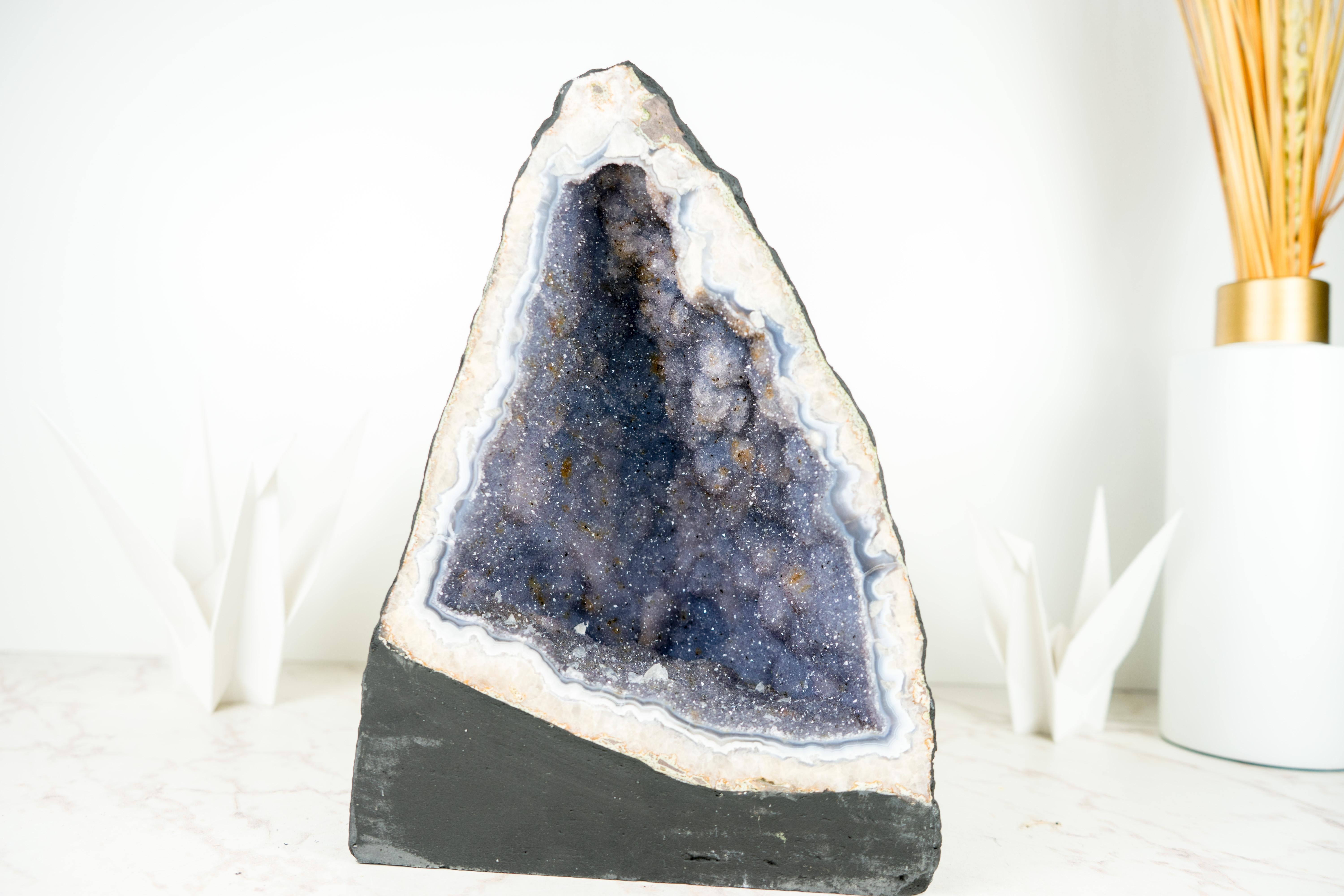 Seltene Achat-Amethyst-Geode, mit Lavendel-Galaxie-Amethyst-Druzy und Calcit

▫️ Beschreibung

Eine natürliche Achat-Geode mit seltenen Eigenschaften formt ein wahrhaft natürliches Kunstwerk. Blaue und weiße Achatbänder, lavendelfarbener