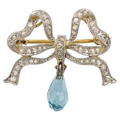 Unique brooch in the shape of a bow with diamonds and aquamarine.