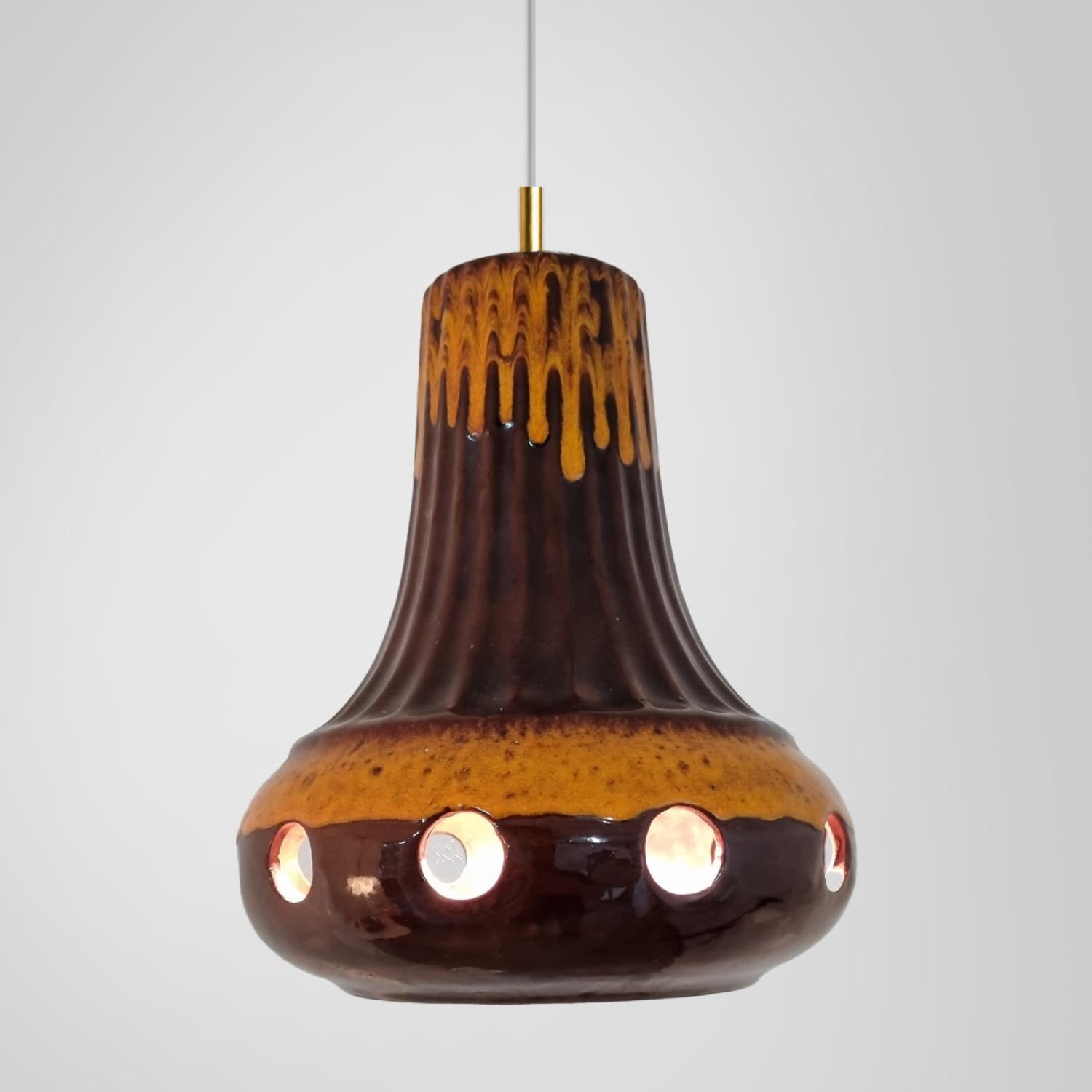 A set of spectacular and stylish ceramic pendant lights made in West-Germany around 1970's. The lights are made of orange and brown glazed ceramic and glazed in 'Fat Lava' style. The orange and brown ceramic fits beautifully with warm, gold or clear