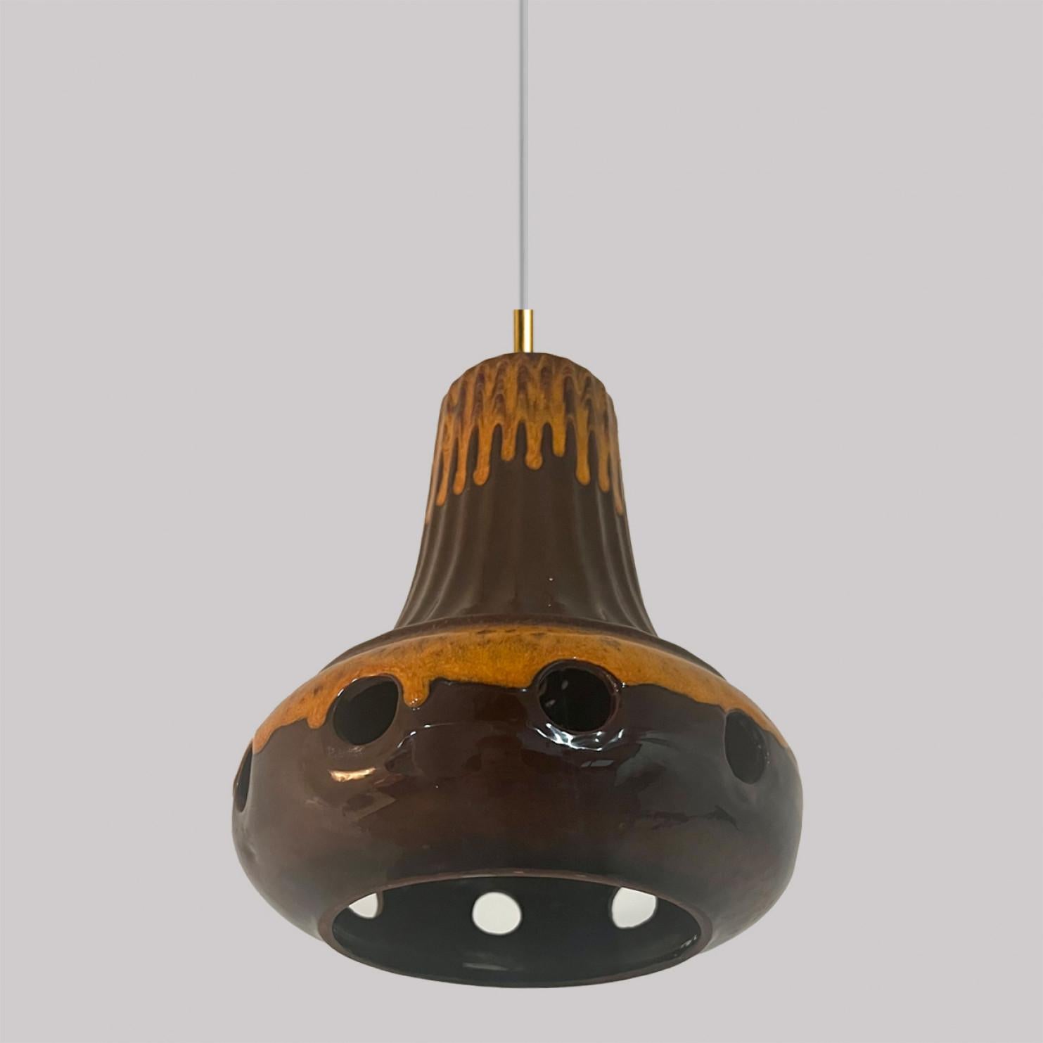 A set of spectacular and stylish ceramic pendant lights made in West-Germany around 1970's. The lights are made of orange and brown glazed ceramic and glazed in 'Fat Lava' style. The orange and brown ceramic fits beautifully with warm, gold or clear