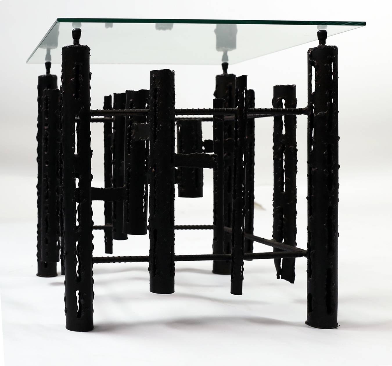 Unique sculptural cast metal base with a glass top. Can also be turned into a coffee table by using a larger glass top. Extremely versatile. 
