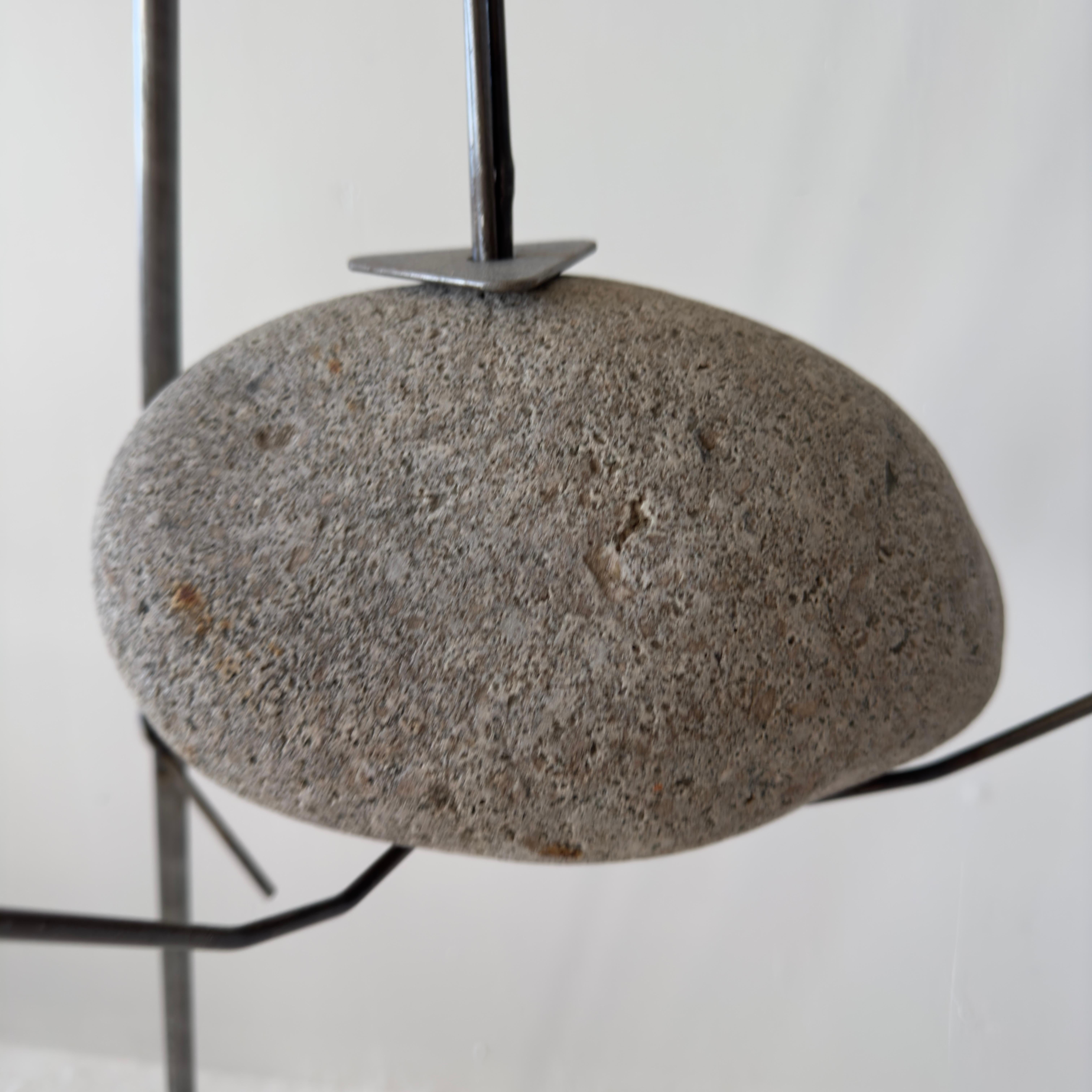 Unique brutalist suspended stone floor lamp with twisted metal. Sourced from a home near Joshua Tree in California. H67 W22.5 D22.5

