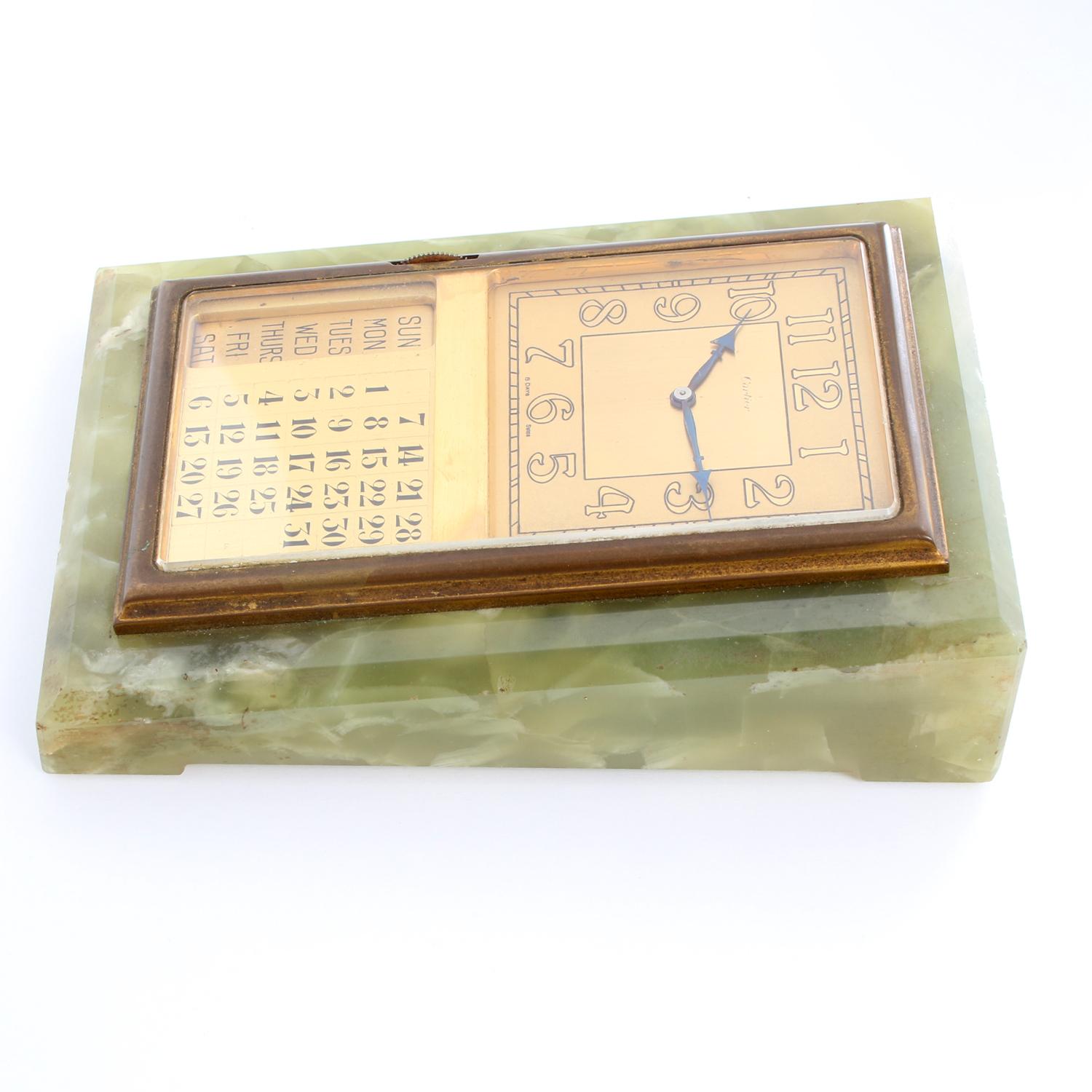 Unique Cartier Brass Mounted Calendar Desk Clock - Manual winding. Brass mounted. Champagne dial with Arabic numerals. Beautiful calendar desk clock. The dial is signed Cartier. The days of the week change as the calendar changes. Keeping perfect