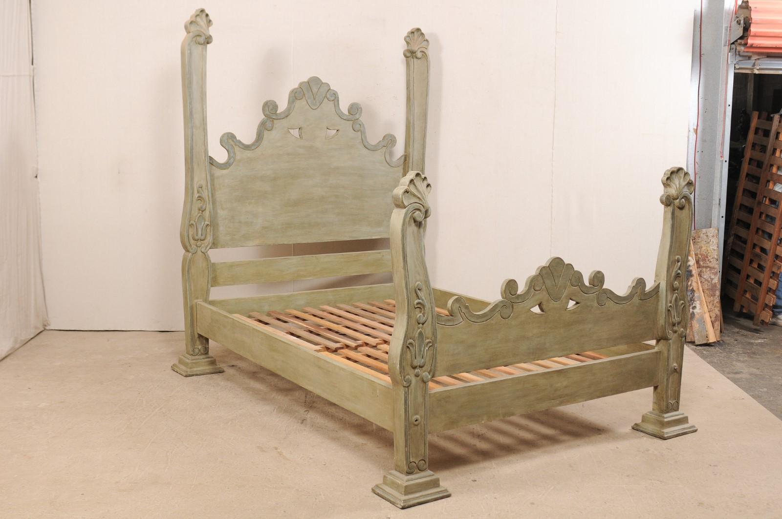 A Brazilian hand carved and painted wood queen bed from with tall head and foot boards. This impressive queen bed, made from tropical hard wood, features a substantial headboard with arch shaped center in a fluid motion of scrolls and pierced