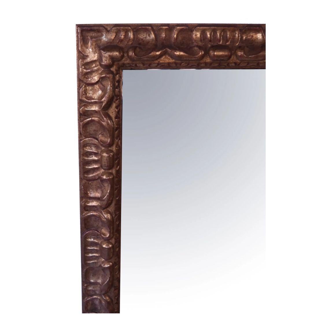 Miroir rectangulaire biseauté en bois sculpté et doré, unique en son genre. Le cadre, fabriqué en bois de haute qualité, est magnifiquement doré, créant un riche éclat doré qui rehausse sa présence sophistiquée. Le miroir présente de délicates