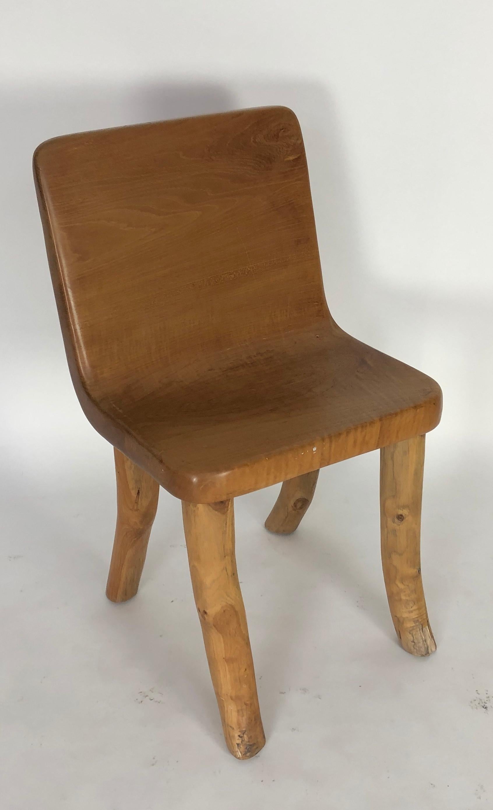 One of a kind chair, a true conversation piece. The body of the chair is carved from a solid piece of teak and the solid legs have been added. Unique in design. Solid, and ideal for either inside or out. The artist has created three of these chairs,