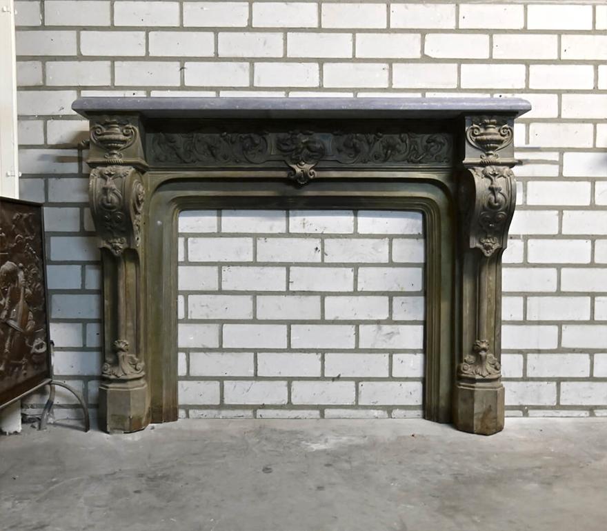 Very unique cast iron fireplace mantel with a Belgian bluestone top on it.
To place in front of the chimney. A piece very hard to find.

