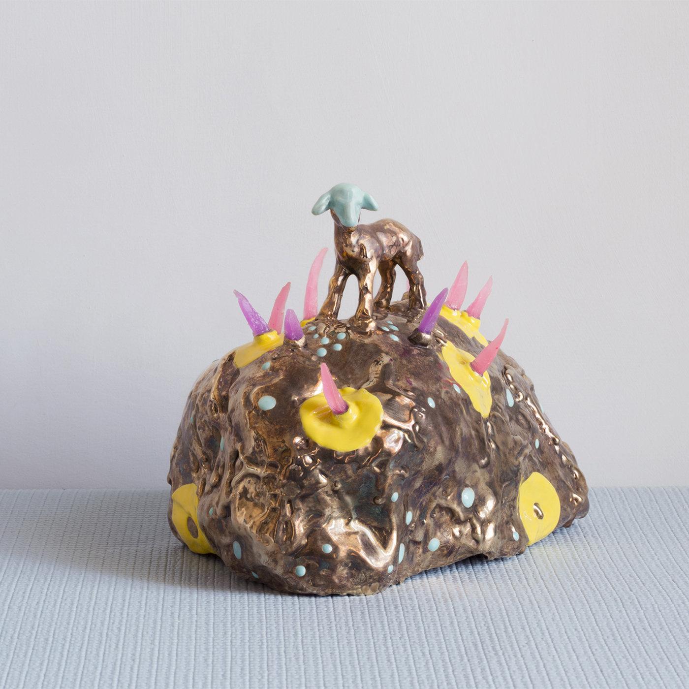 These eccentric pieces are made in total freedom and experimentation, with the addition of silicone, crystals, porcelain animals and some small remnants from production. Here, a small animal stands on a rock style surface with colored detail. A