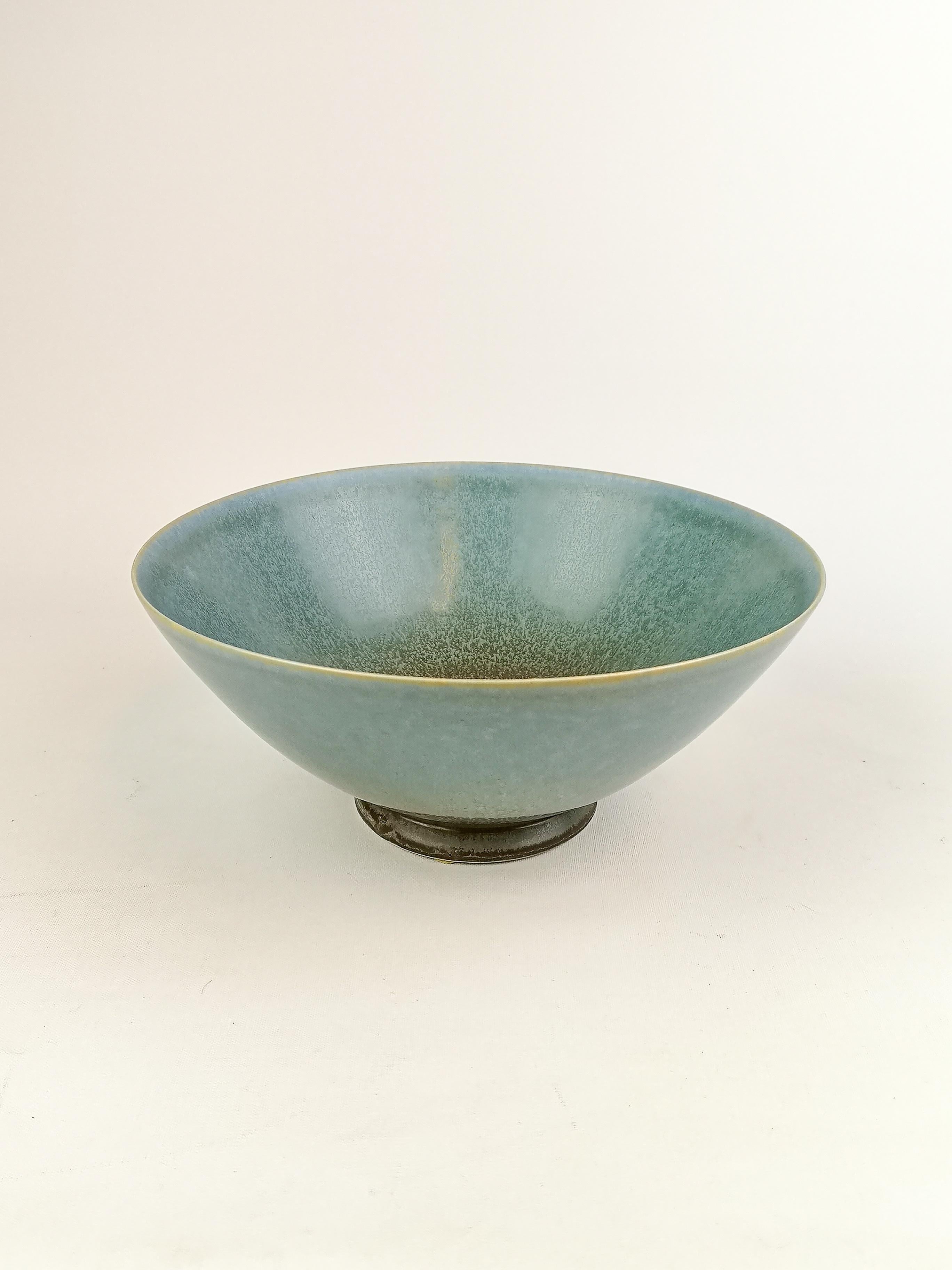 This bowl was handmade and glazed in the K-studio factory at Gustavsberg by Sven Wejsfelt. At the K-studio designers was given the spirit to produce unique art for Gustavsberg. 
The bowl is perfectly shaped and has a wonderful green /blue