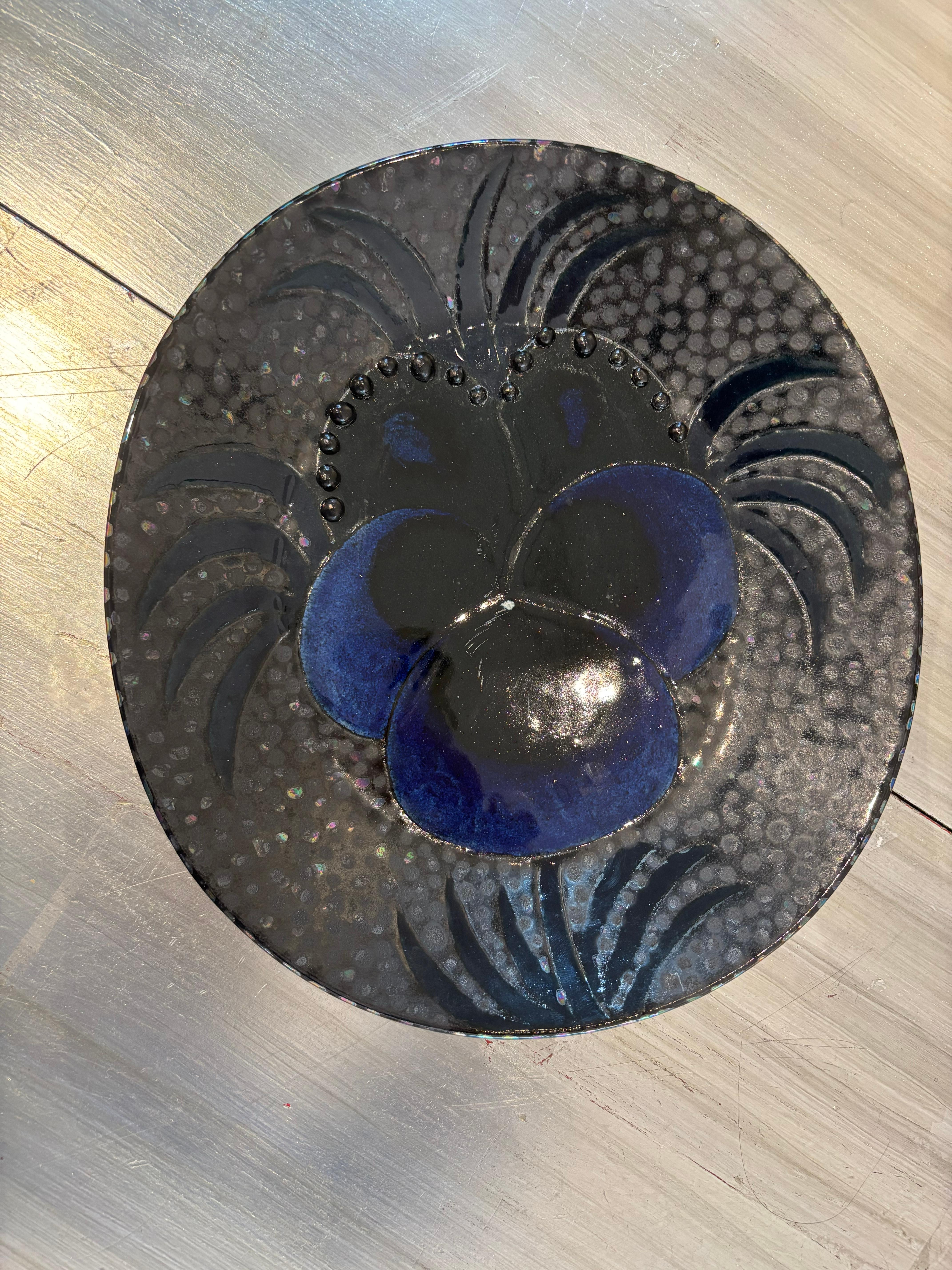 beautiful work by finnish ceramicist birger kaipiainen who was famous for his unique platters working with various techniques and colors, focussing on botanical motives - here shown his typical pansy on a back, slightly iridescent and dotted