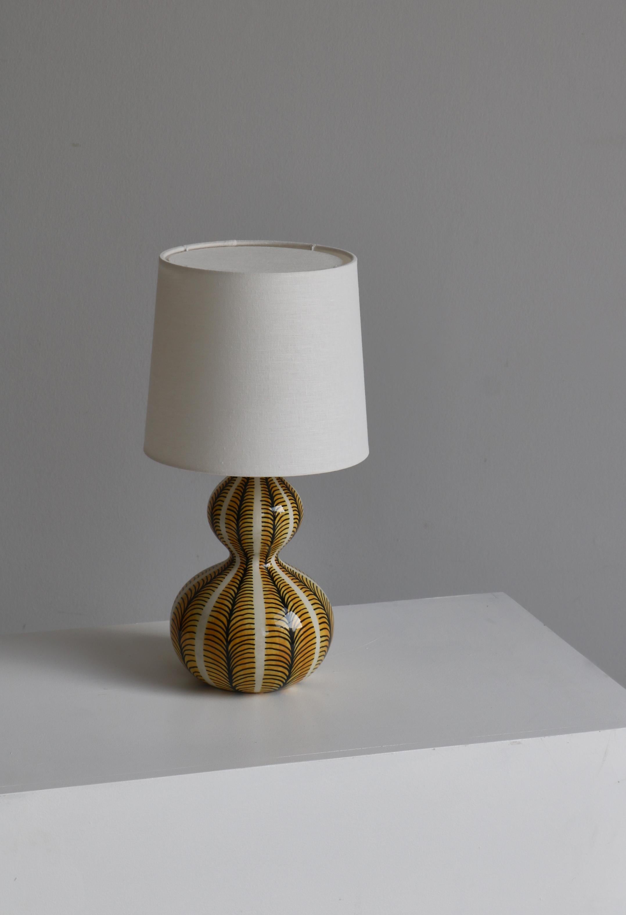 Lampe de table en céramique en forme de gourde fabriquée par Eva et Johannes Andersen dans leur Studio à Copenhague, Danemark, dans les années 1950. La lampe est décorée à la main et émaillée ensuite. Signé 
