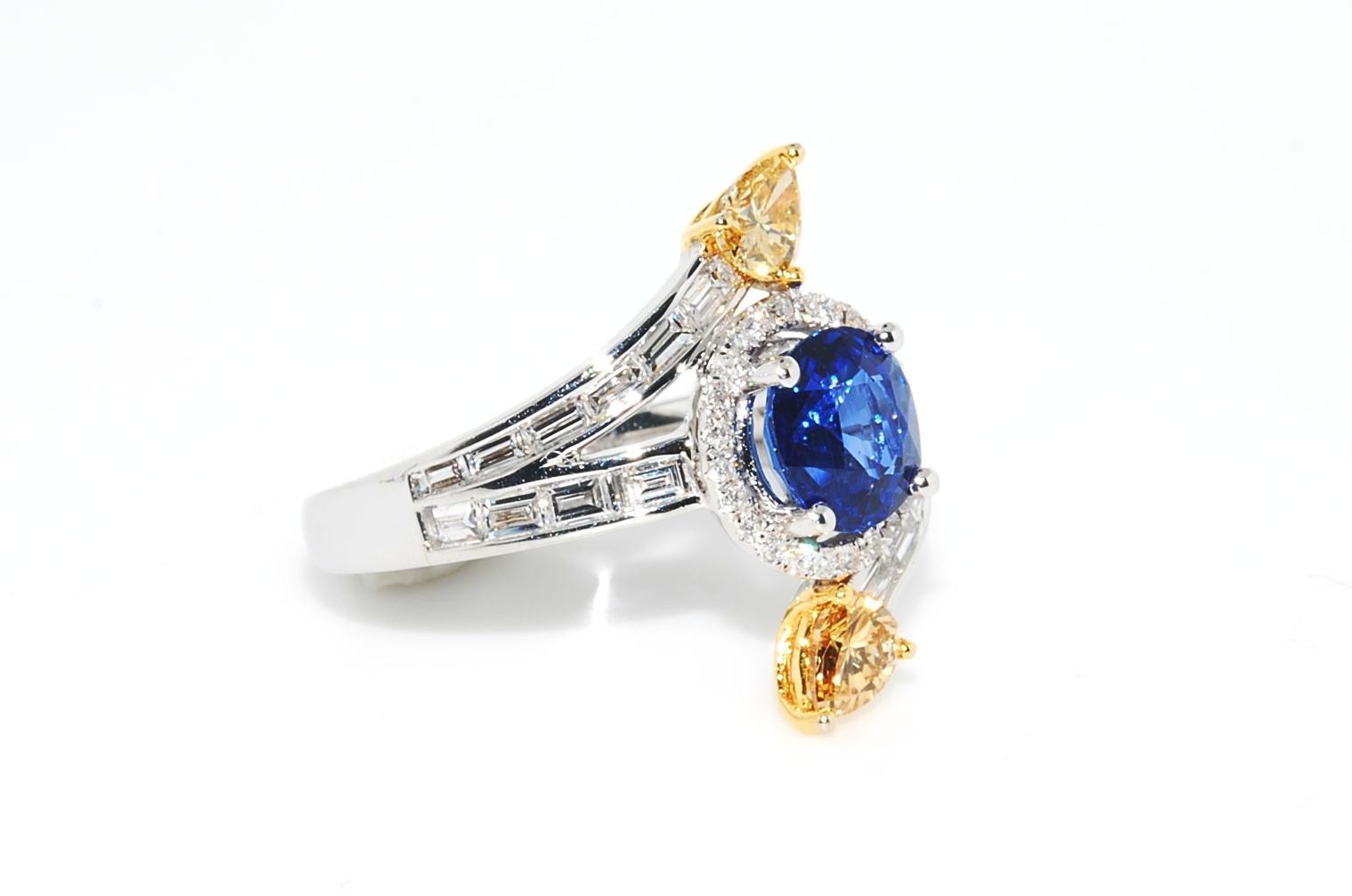 1.86 carat top quality sapphire 6.95 x 6.52 x 4.65mm's prong set in 6.9 grams of 18 karat white gold. This beautiful sapphire is surrounded by a halo of G VS round full cut diamonds (.24cts). It also features 18 baguette diamonds (.24 cts) and two