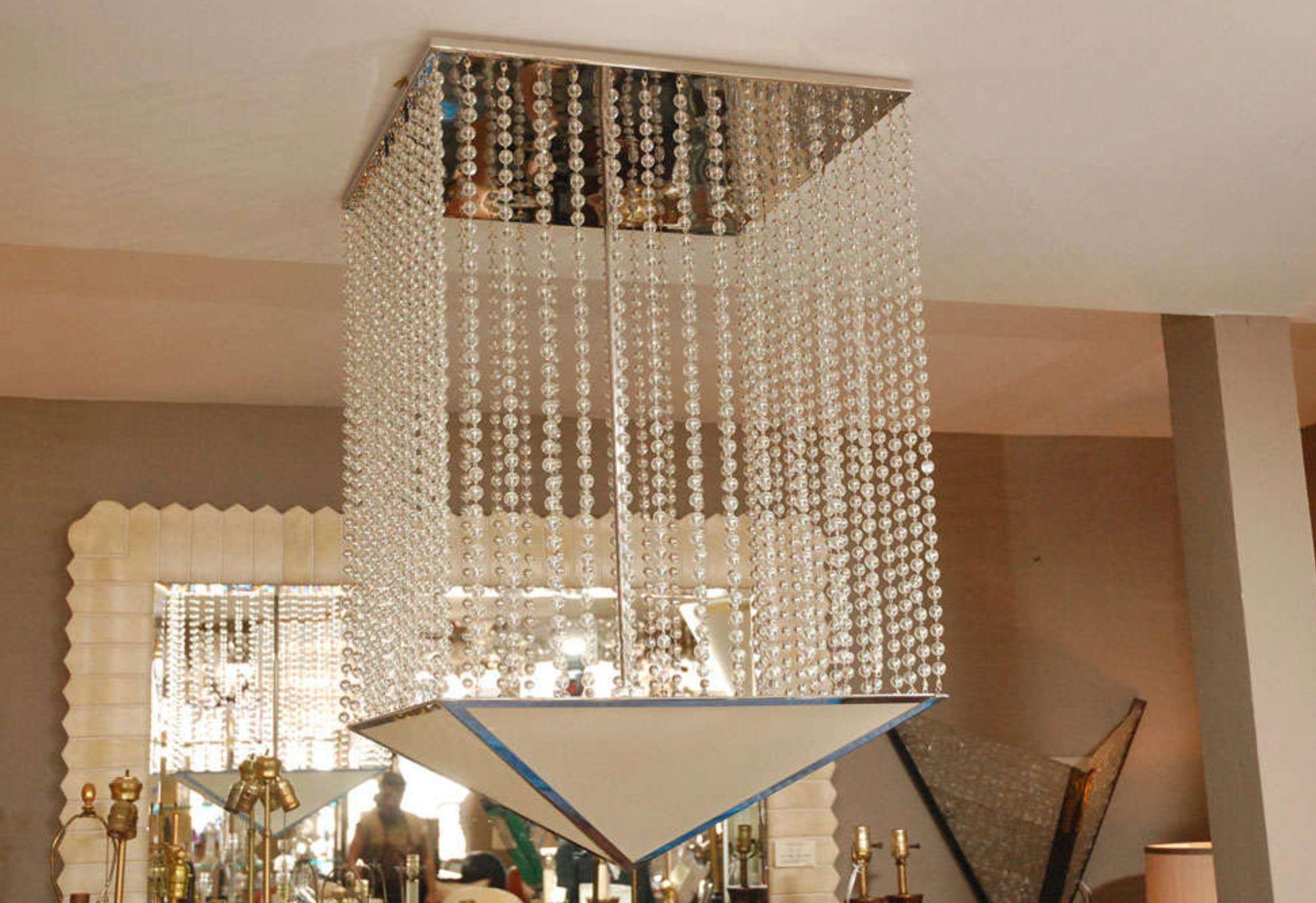 This is a prototype chandelier by Bryan Cox. Composed of hanging glass beads from a nickel ceiling plate. Shade is made of stiff linen framed in nickel.