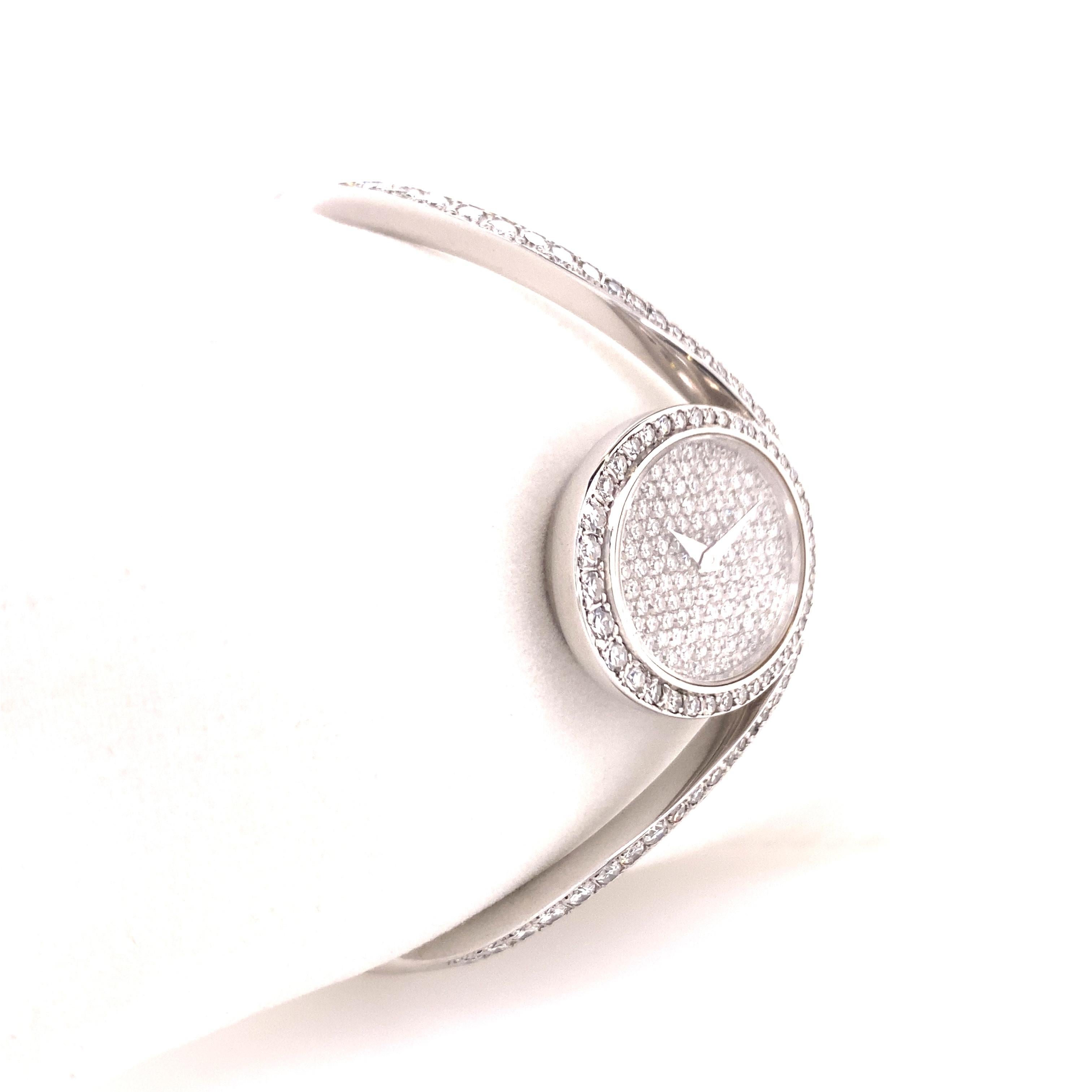 Super stylish and rare diamond bangle watch in 18K white gold by Swiss Jeweller Chopard. 
Oval pave-set diamond case with full set dial elegantly integrated in a curved hinged bangle bracelet. The diamonds weigh approximate 3.50 ct in total. The box