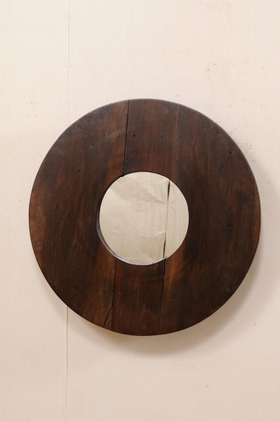 This custom mirror has been creatively up-cycled with an old N. African wooden cooking utensil as the surround, with new mirrored glass in it's center. This mirror features a circular-shaped mirror, within a round-shaped wooden frame from N. Africa,