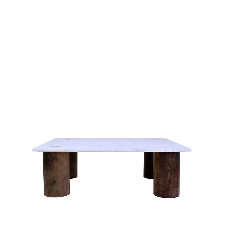 This simple coffee table is an impressive slab of white Carrera marble, which rests on four large teak column-like legs. The tenons of the wooden legs extend through the stone to reveal the connection and hold the slab in place.
Wear consistent with