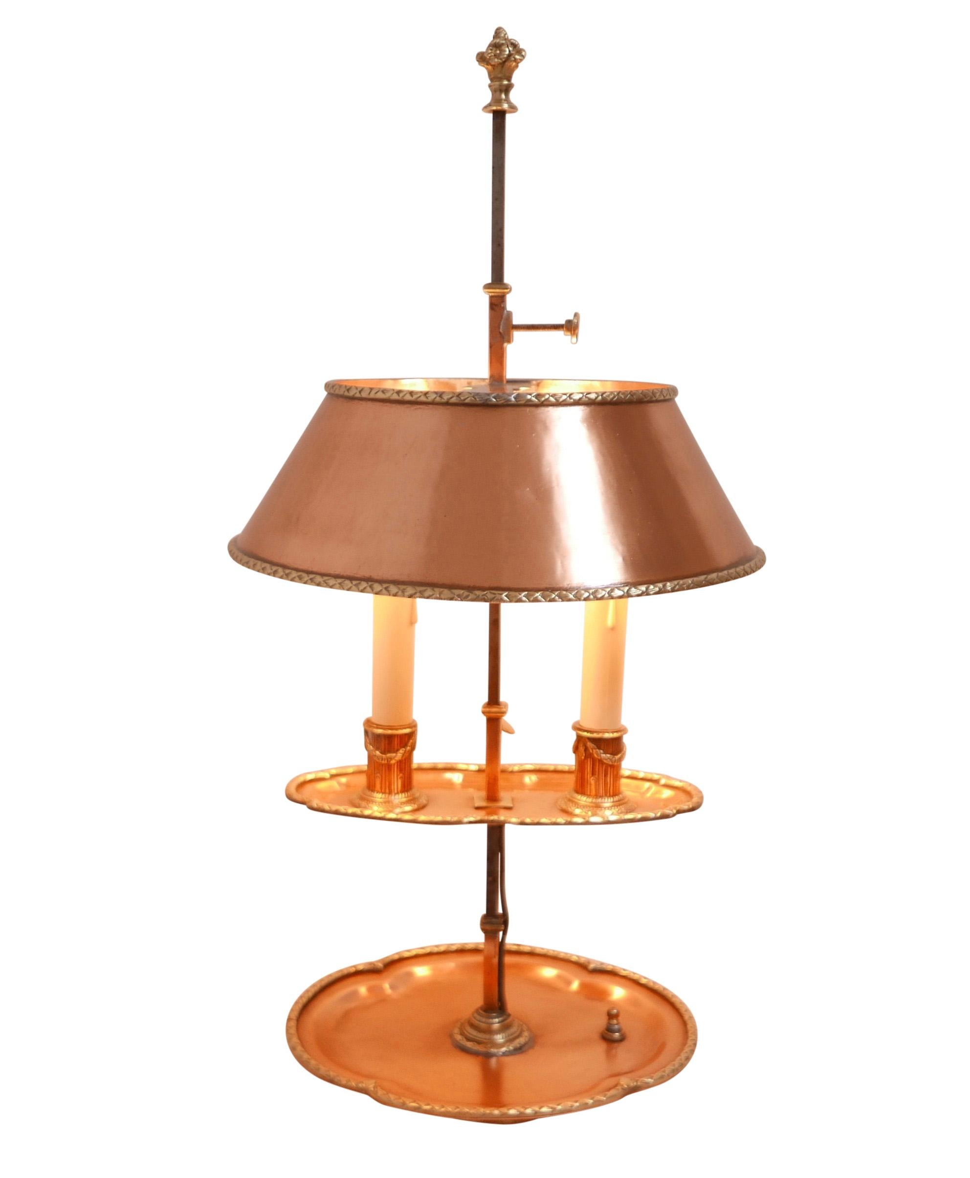 A wonderfully unique oval shape copper with brass accents two light Bouillotte lamp. Brass trim around the saucer and drip pan as well as the top and bottom of the copper shade. The two fluted candle holders decorated with brass swags.
Recently