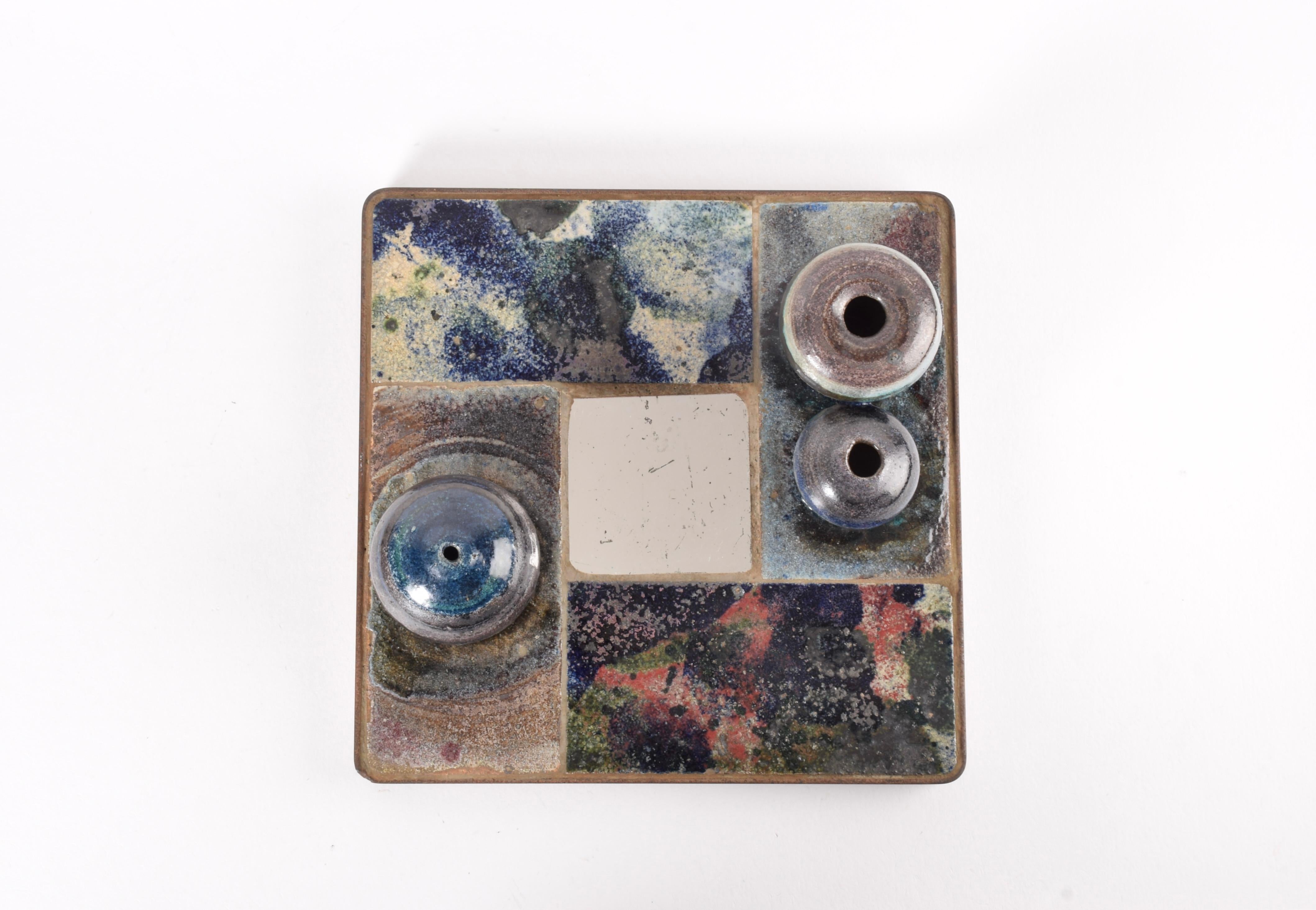 Unique Danish ceramic wall art in brutalist style by Danish ceramist Mette Høm (1938-1989). Made ca, 1960s in Mette Høm’s own studio.

The wall art is made from tiles and vase shaped objects and glazed in a mix of colors. In the center is a small