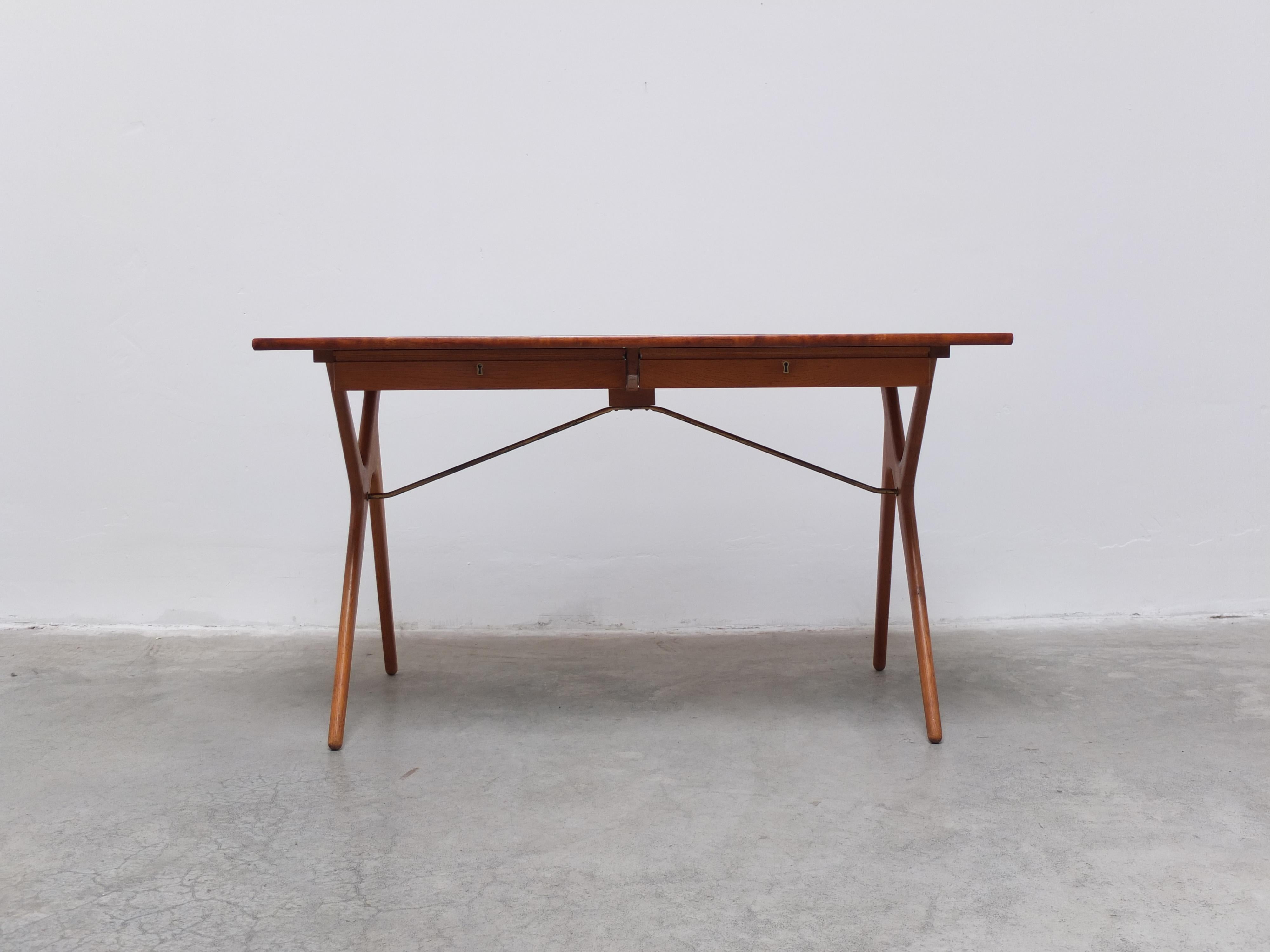 Rare desk produced in Denmark during the 1950s. The top is made of teak and the refined compass legs of solid oak. The whole is connected through a brass support bar. Underneath the top there are two compact drawers. Designer unknown but a great