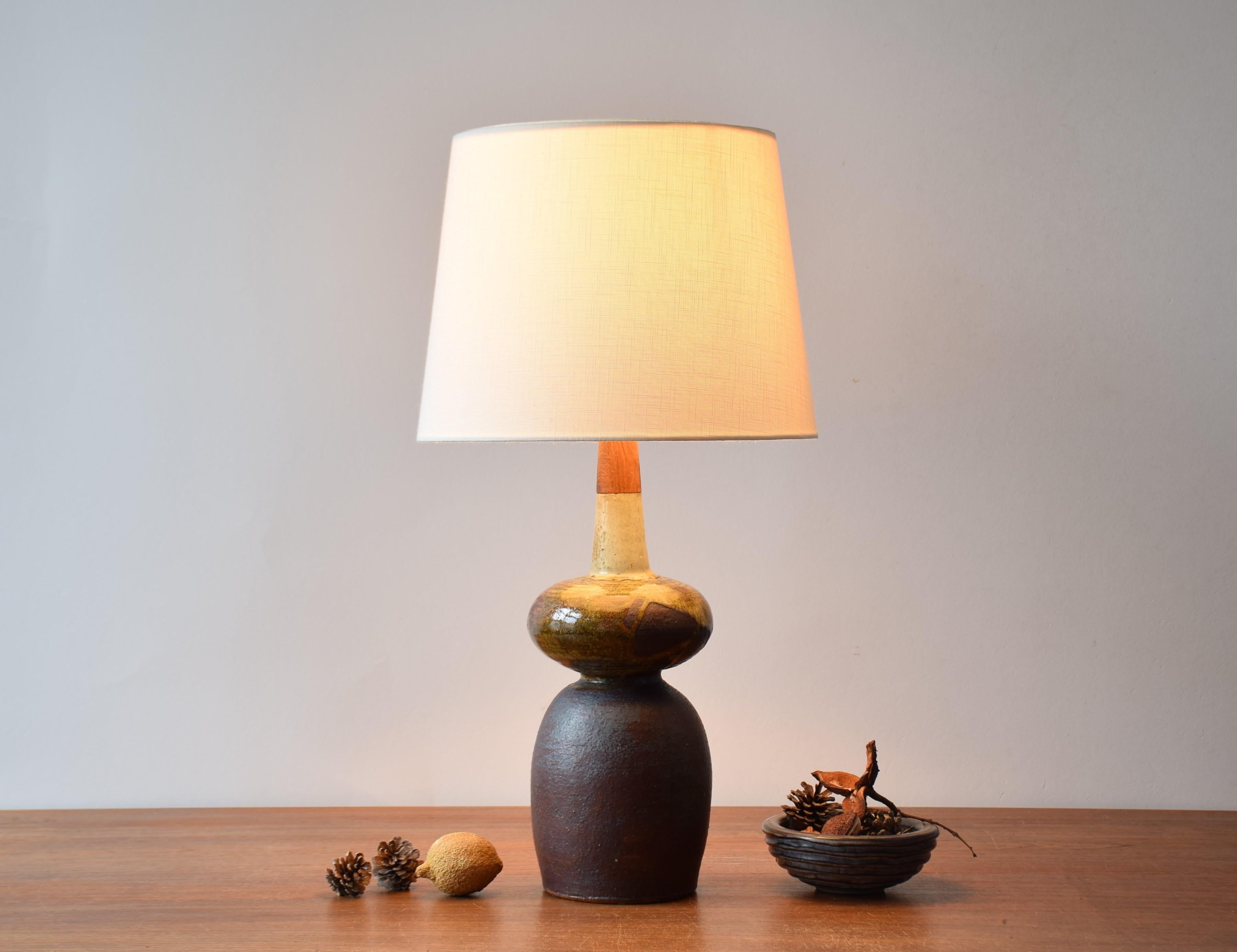 Unique Mid-century Danish studio pottery table lamp by ceramist Erik Graeser, made circa 1960s-1970s.
Great sculptural shape and interesting contrast between ceramic body and top made of solid teak wood. The colors are earthy brown tones.