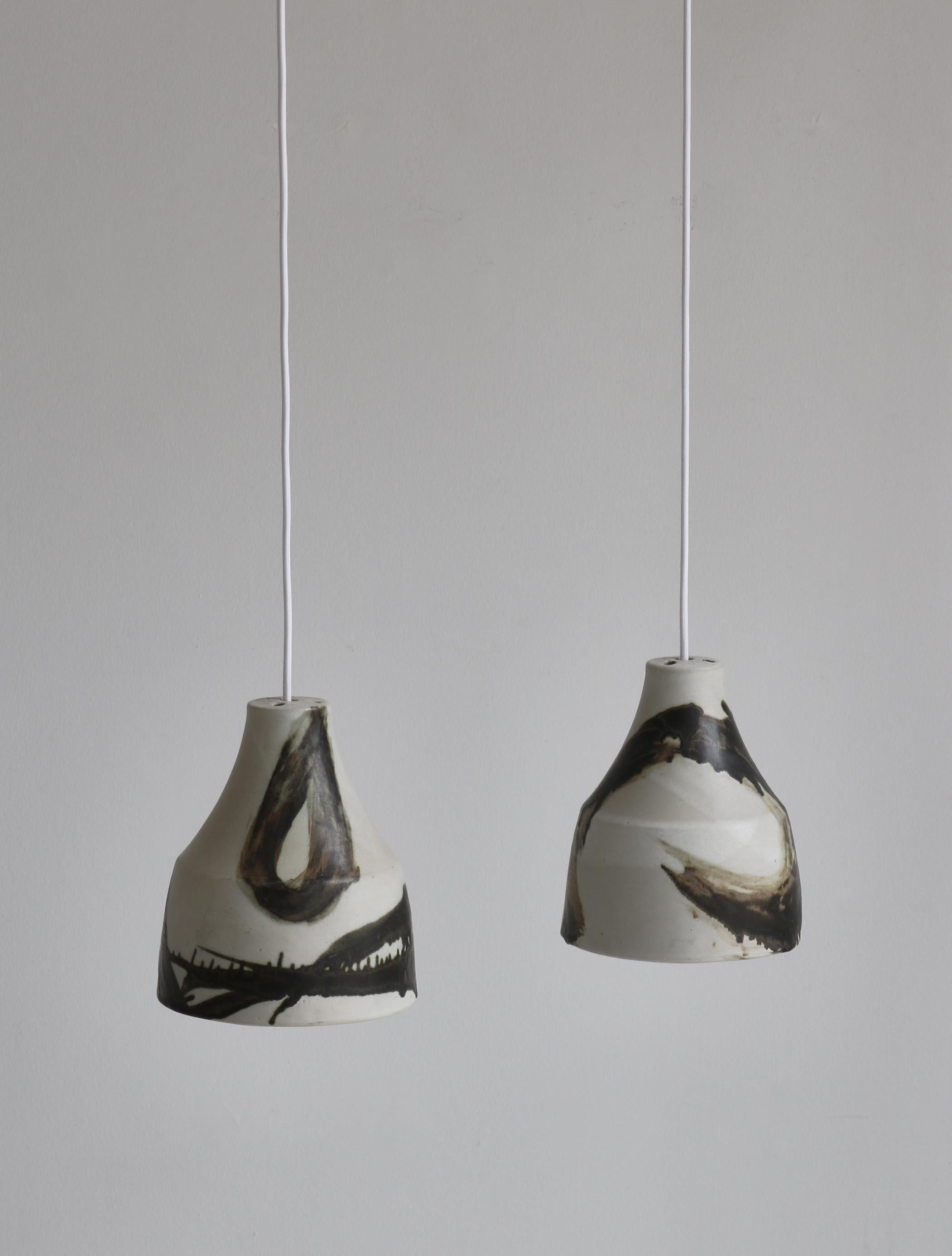 Beautiful pair of unique stoneware pendants in white and brown glazing handmade in Denmark in the 1960s. Attributed to Søholm Stentøj at the island of Bornholm, Denmark. 
The Søholm Pottery on the small island of Bornholm in Denmark was established