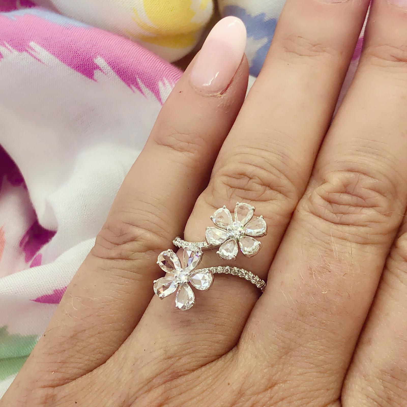 Delicate yet bold, this 18k white gold by-pass ring is charming and unique. Designed with two flowers, featuring pear-shaped rose-cut diamond petals, and round-brilliant-cut set stems creating the band. The total diamond weight is 1.84 carats. The