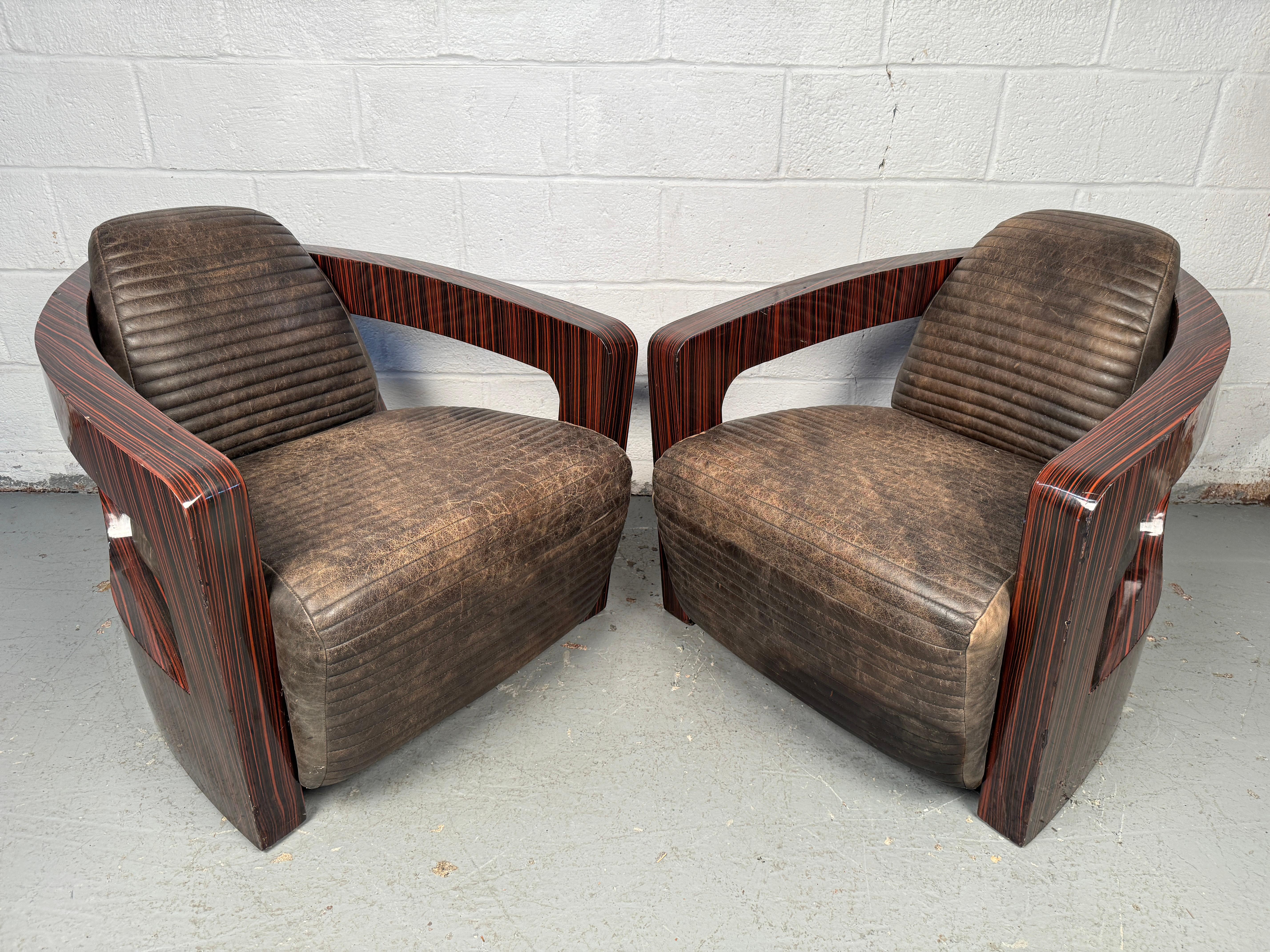 Unique pair of lounge chairs designed by Timothy Oulton, combining sleek ebony veneer frames with supple leather upholstery. The sculptural design and rich materials create a bold, sophisticated look while offering exceptional comfort. A
