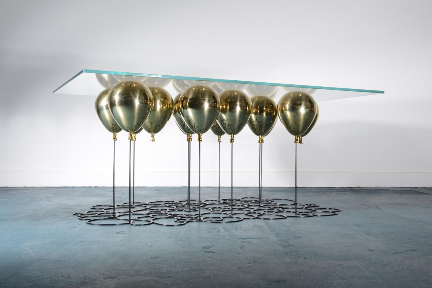 Unique edition piece.

Rectangular UP! Balloon Coffee Table with matte black powder-coated legs and gold balloon finish. Toughened, laminated, low-iron glass table-top.

The UP Balloon coffee table is a playful trompe l’oeil furniture piece. A