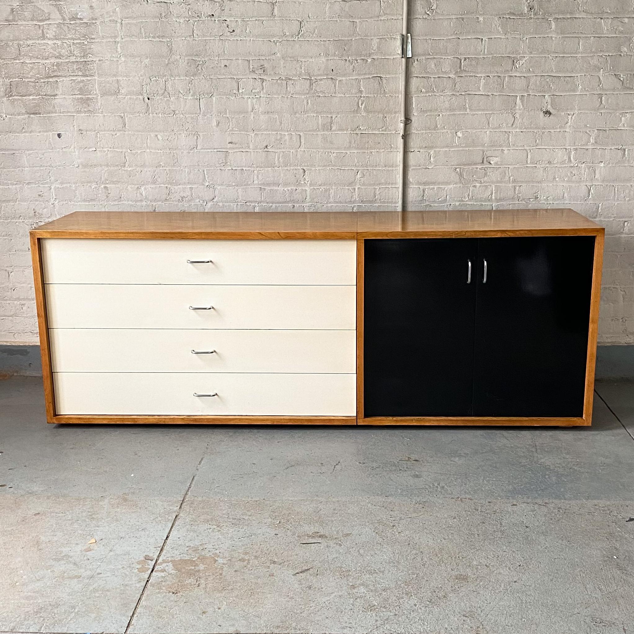 Two-piece custom cabinet of birch with black-and-white lacquered fronts, designed by Elaine Lustig Cohen (1927-2016) circa 1961 for her own townhouse on the Upper East Side in New York City, where it remained until 2018. The simple but graphically