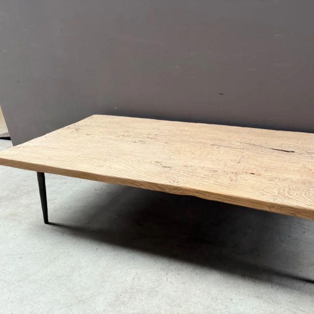 This wabi sabi and minimalist coffee table combines rustic charm with modern lines, making it a versatile centerpiece for any living space. The top is crafted from solid elmwood sourced in Asia and is likely nearly 100 years old. Its rich natural