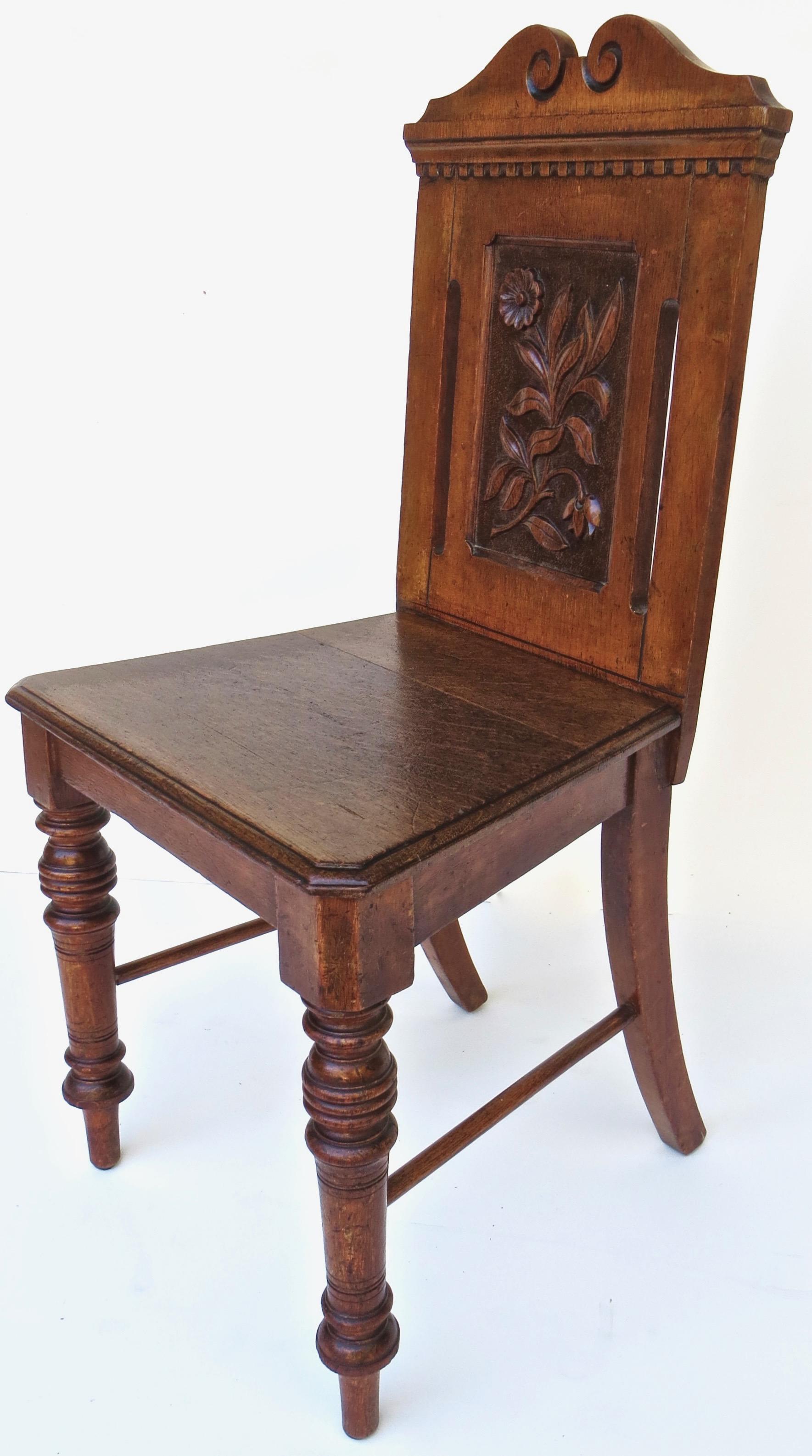 Late 19th century very unique English side chair in solid oak with carved back in floral motif. Two long vertical open slats (one to each side of the back) add to the unique design of this Victorian chair. The top carved and crested rail with a