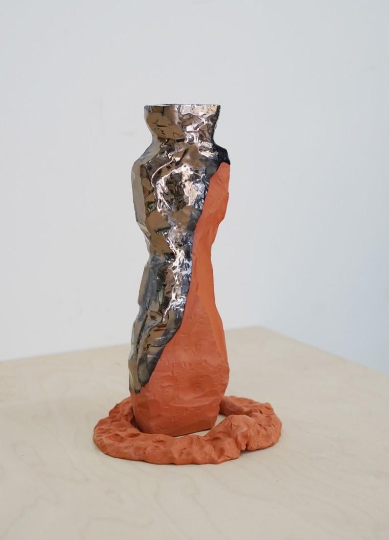 Vase sculptural unique ÉNOTA_21_04 d'Emmanuelle Roule
Pièce unique
Dimensions : L 10 x H 30 cm
Matériaux : Faïence

Pièce unique faite à la main en faïence rouge partiellement émaillée. Avec des reflets à effet métallique. Non imperméable à