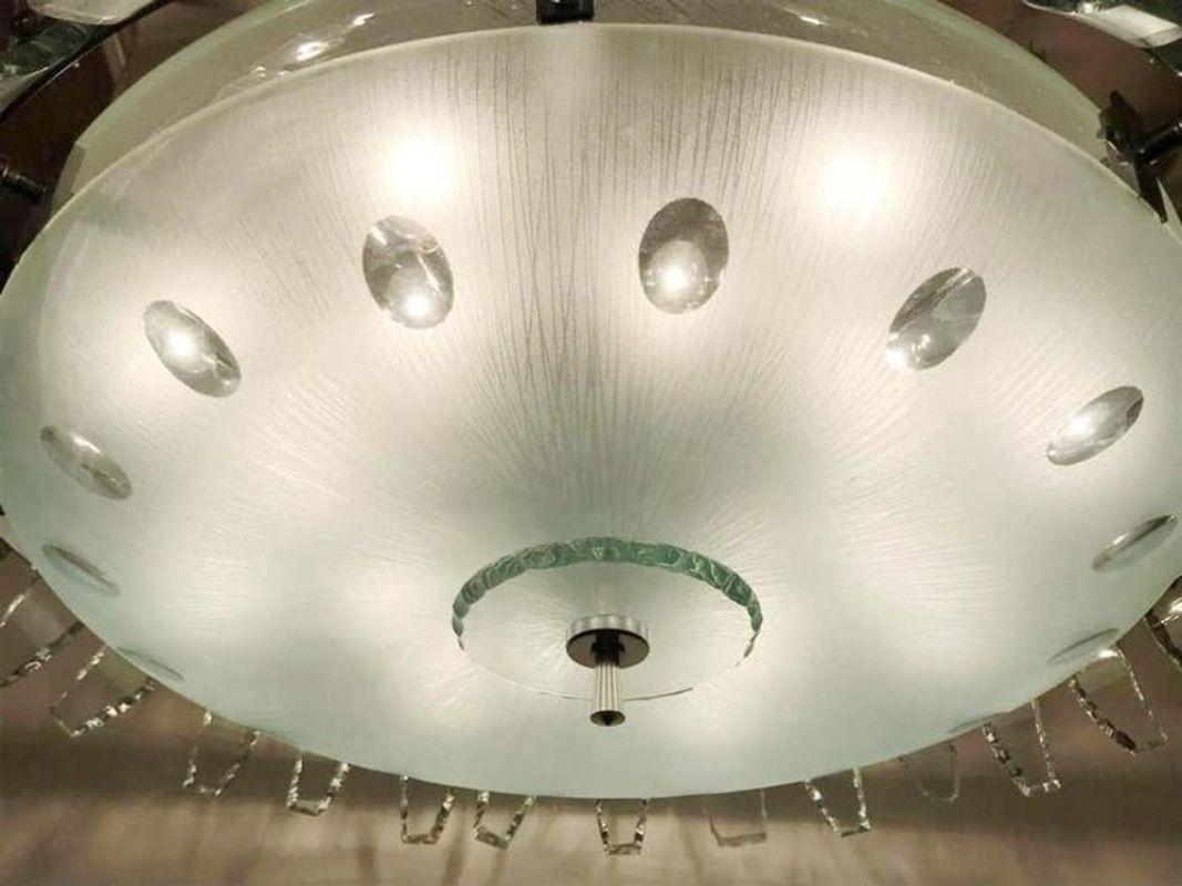 Vintage Italian chandelier with frosted glass shades surrounded by aqua etched glass petals around the perimeter, supported by a chrome finial and stem, chrome chain and canopy.
In the style of Fontana Arte, circa 1960s, made in Italy.