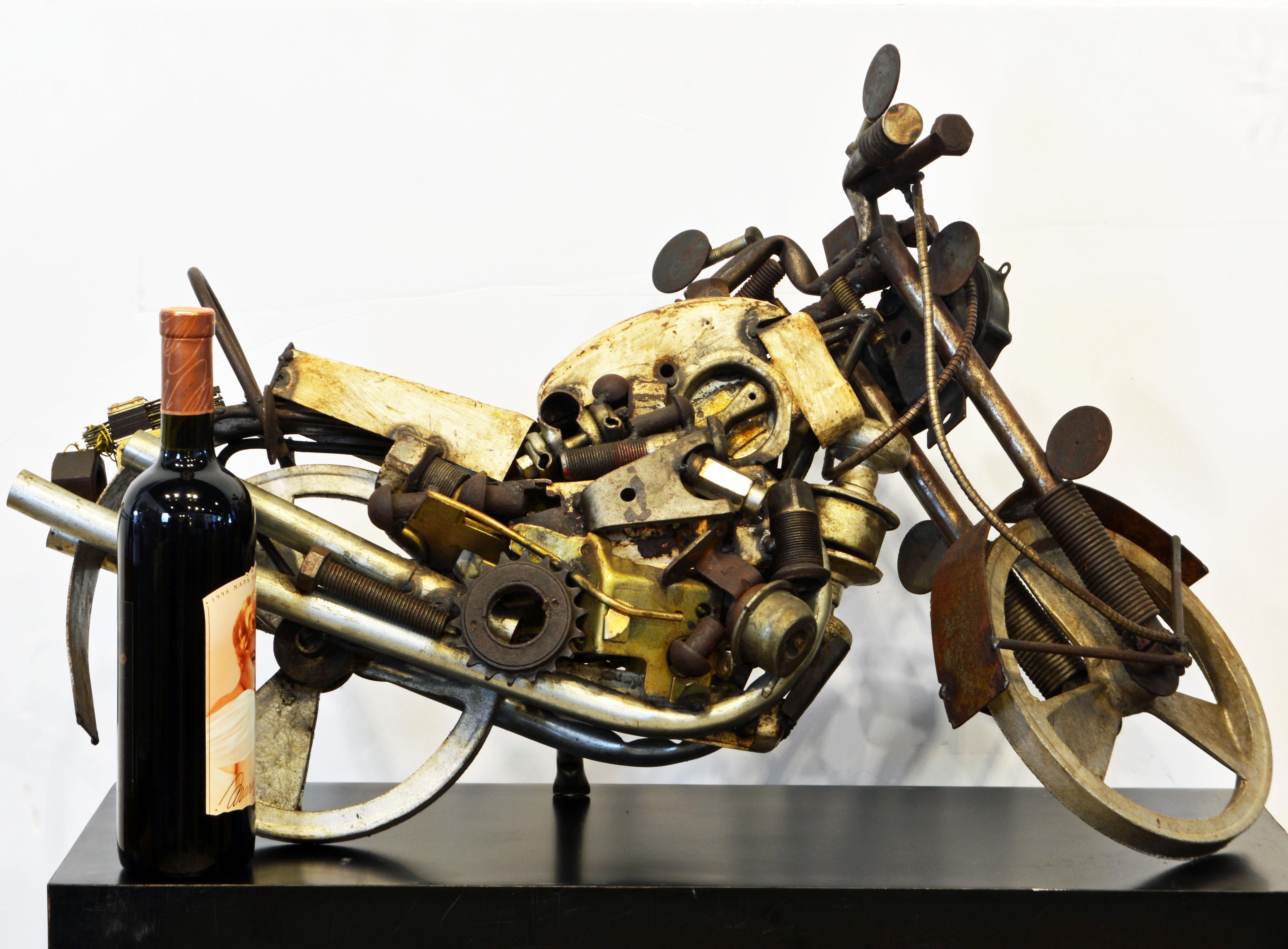 The artist behind this motor cycle sculpture has with great fantasy captured the very essence of a motor bike resting on its kickstand using an array of smaller scrap metal and mechanical parts. Even the front wheel is movable.