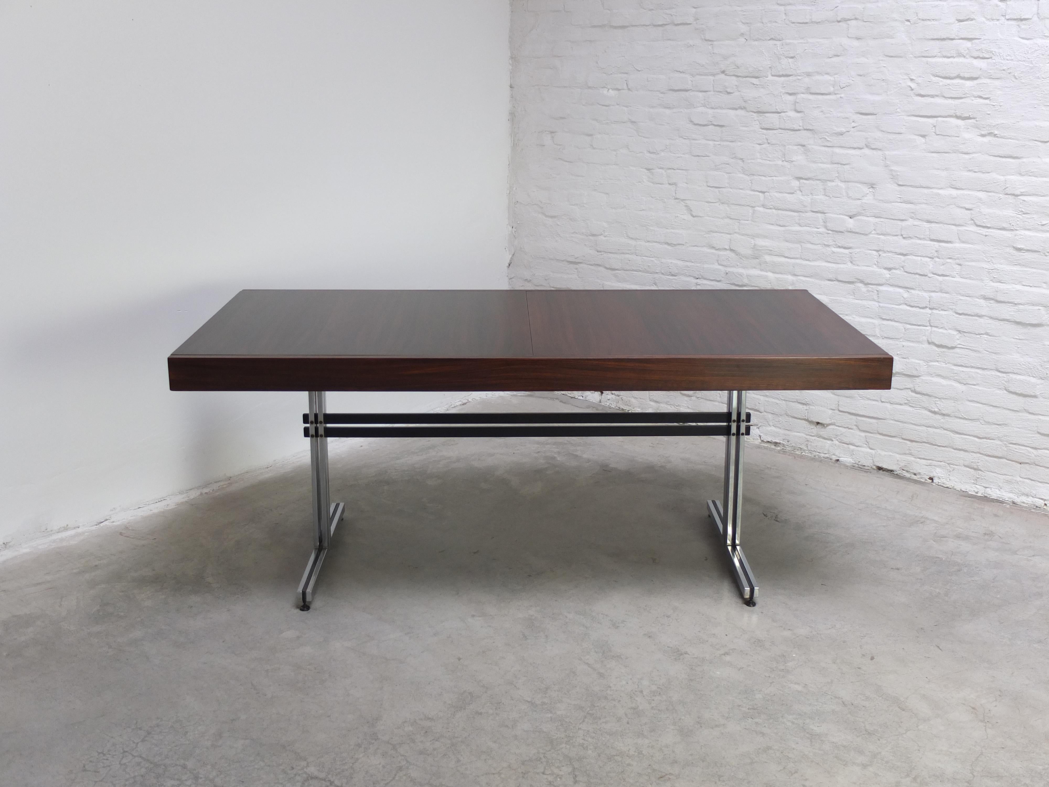 Exceptional modernist dining table or freestanding desk designed by Jean Batenburg for E.M.Y. around 1965. It features a beautiful top which can be extended from 180cm-240cm thanks to a central leaf. The refined metal base with sledge feet gives
