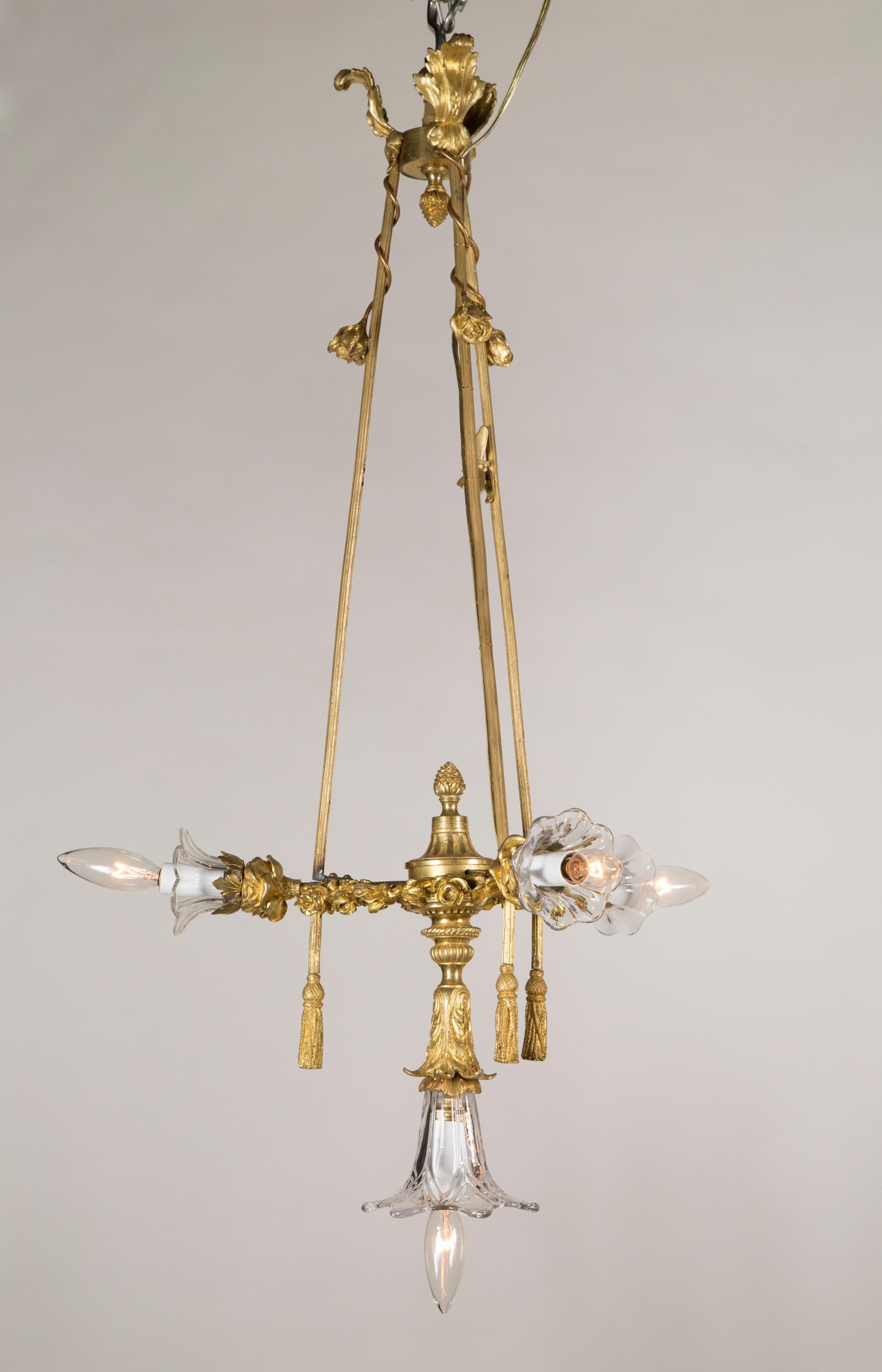 Questo lampadario francese Luigi XVI, incredibilmente unico, presenta un bellissimo design a corda e nappe e risale alla fine del XIX secolo. I dettagli sono abbondanti; nota le foglie d'acanto in alto e il terminale della corona che si specchia nel