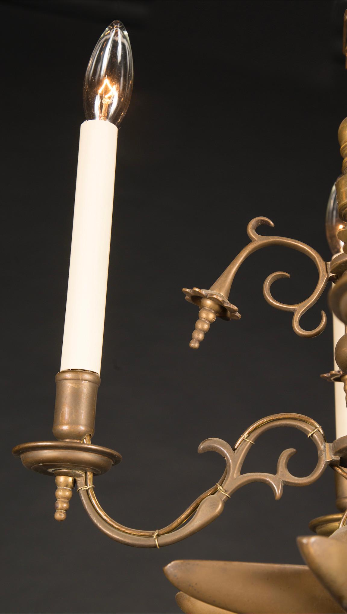 Ce lustre français en laiton date du XIXe siècle et présente une myriade de détails uniques. En particulier, la tige supérieure ressemble à une lame de scie, s'étendant du plafond aux éléments situés en dessous. Le bas de la pièce est orné d'une